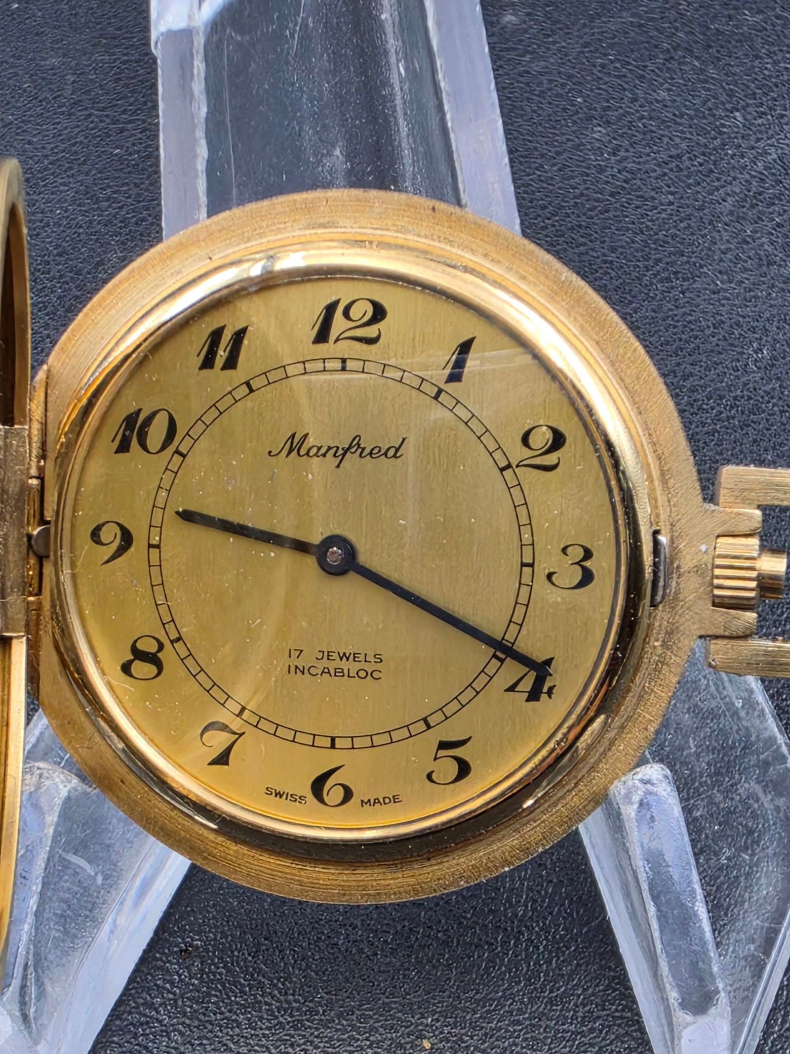 Vintage Manfred Pocket Watch 17J Incabloc Swiss Gold Tone 38mm Mechanical Running: Vintage Manfred pocket watch featuring a gold-tone dial with stylized Arabic numerals and a clean, minimalist layout. Marked 17 jewels Incabloc, indicating a shock-protected Swiss mechanical movement.