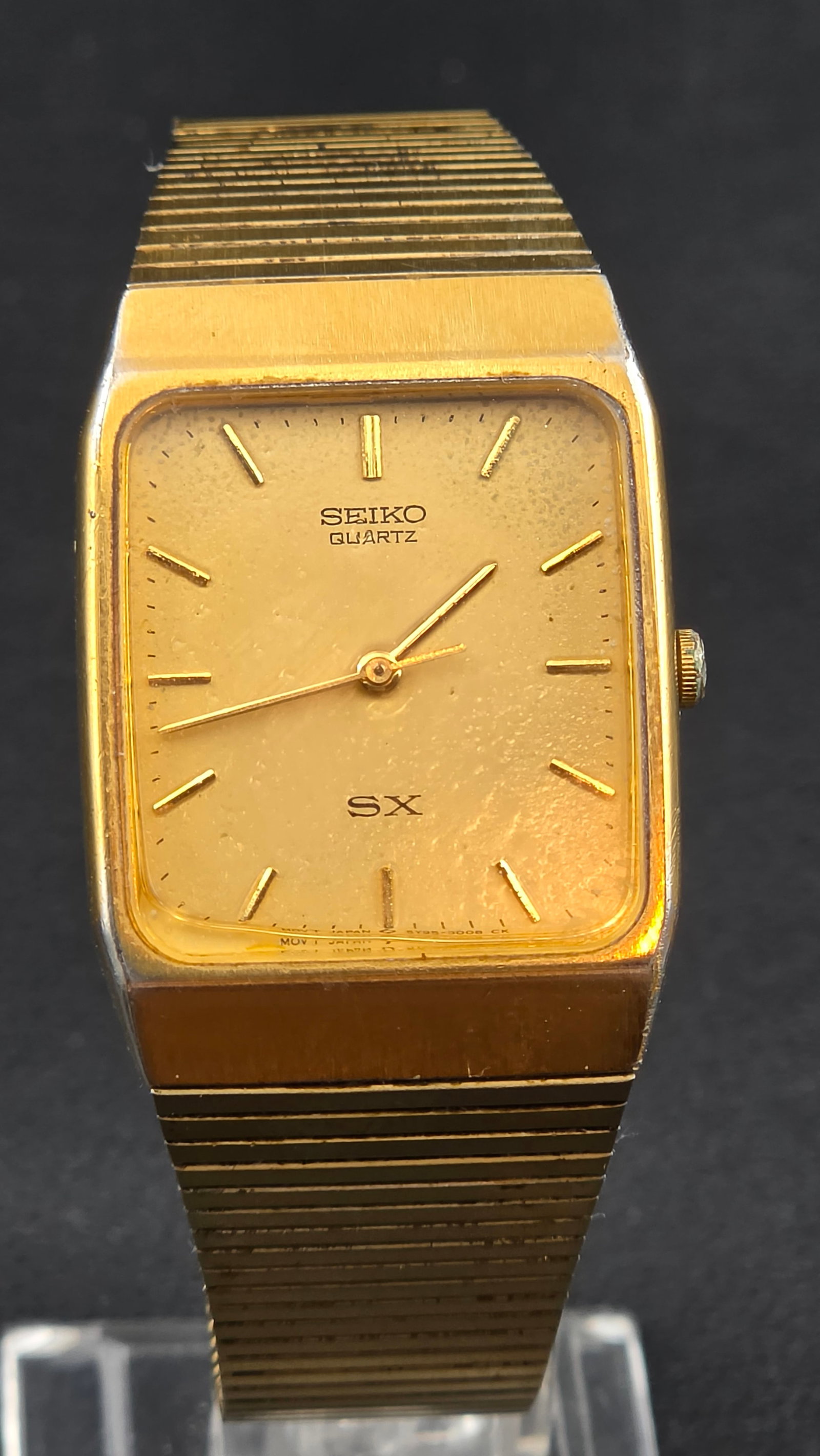1988 Seiko SX Quartz 5Y86-5000 26mm Gold Tone Tank Watch Integrated Bracelet: Vintage Seiko SX quartz tank-style wristwatch with gold tone rectangular case and original integrated bracelet. Gold dial with applied baton markers and minimalist design. Dial signed Seiko Quartz SX.