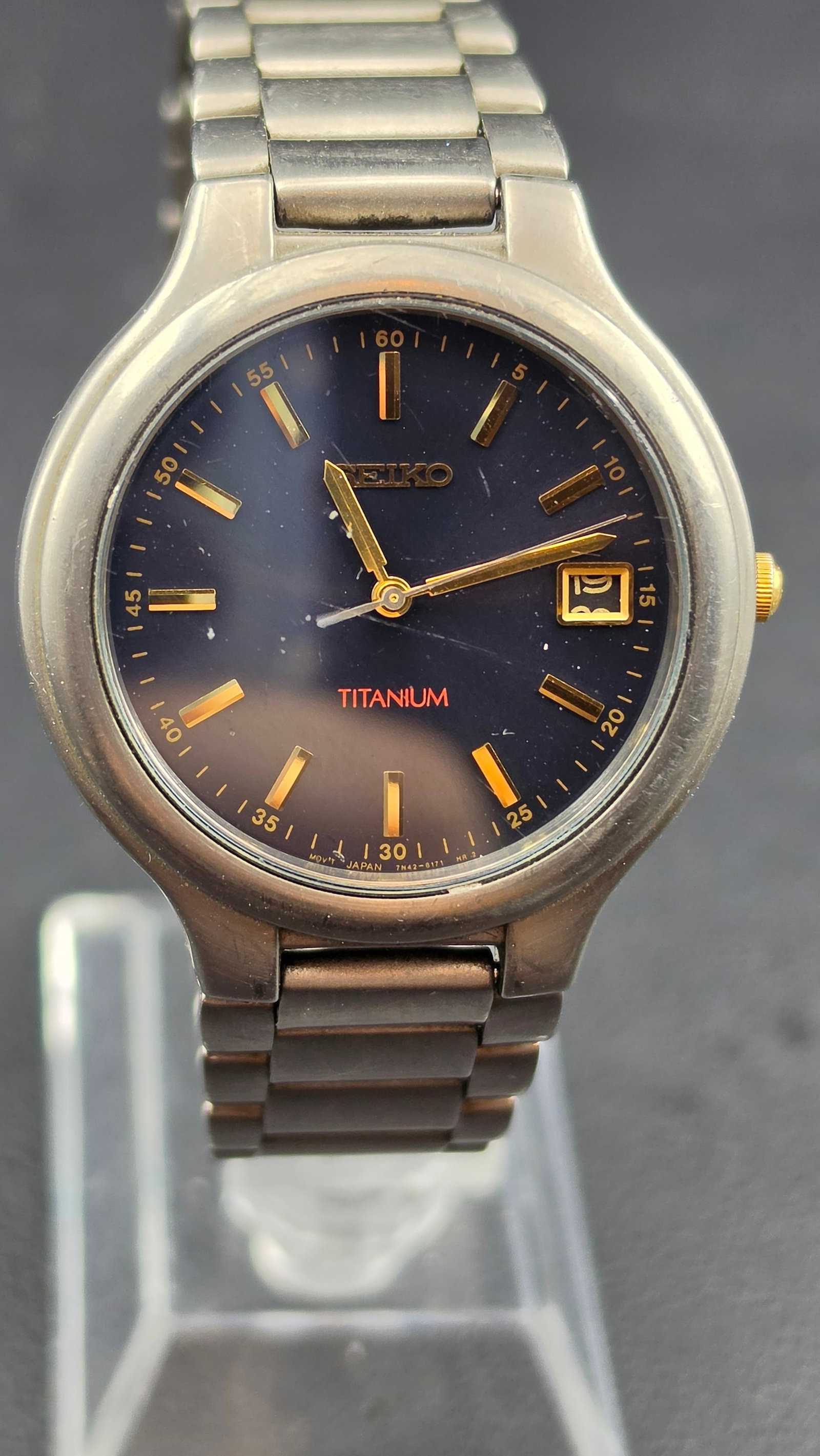 Seiko Titanium 7N42-8119 Quartz Date Watch 37mm Blue Dial Running New Battery: Seiko quartz wristwatch featuring a blue dial with gold-tone markers and date window at 3 o’clock. Lightweight titanium case and bracelet provide comfortable everyday wear. Movement marked 7N42-8119