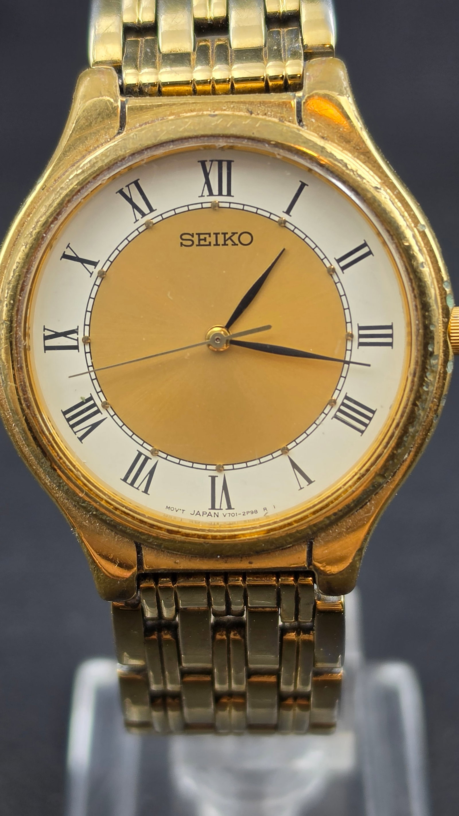 Seiko V701-1Y70 Gold Tone Roman Dial 33mm Quartz Watch Bracelet Japan New Battery Running: Seiko quartz dress watch featuring Japan movement V701-1Y70. Classic two-tone dial with gold center and white outer chapter ring, black Roman numerals, and slim baton hands. Gold tone case with matchi