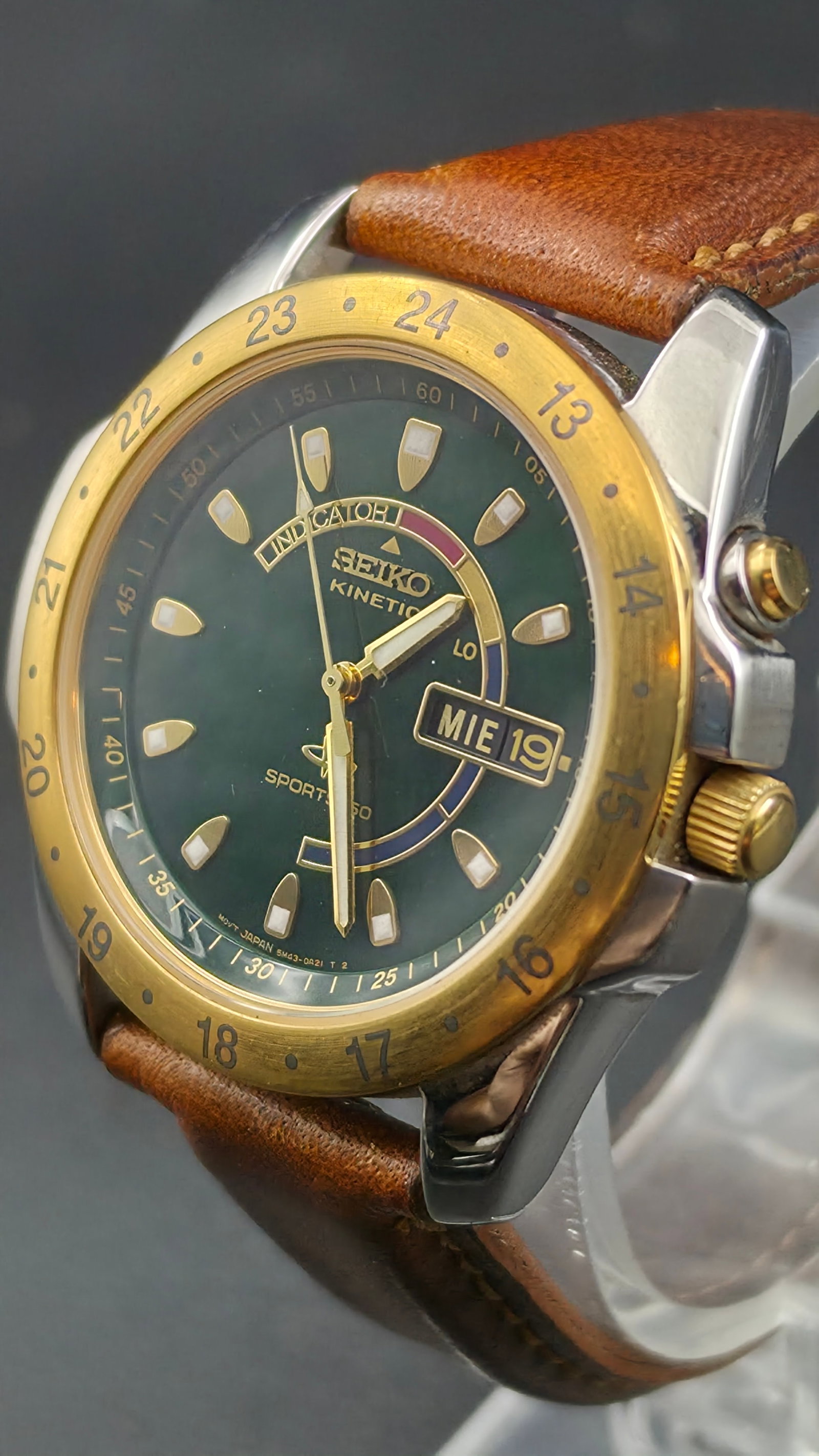 Seiko Kinetic Sports Indicator Men's Watch Green Dial 24-Hour GMT Bezel Day Date Two-Tone 41mm Runs: Up for auction is a Seiko Kinetic Sports Indicator men's wristwatch, a highly desirable and feature-packed timepiece. This bold watch features a deep green sunburst dial with luminous shield-shaped ho
