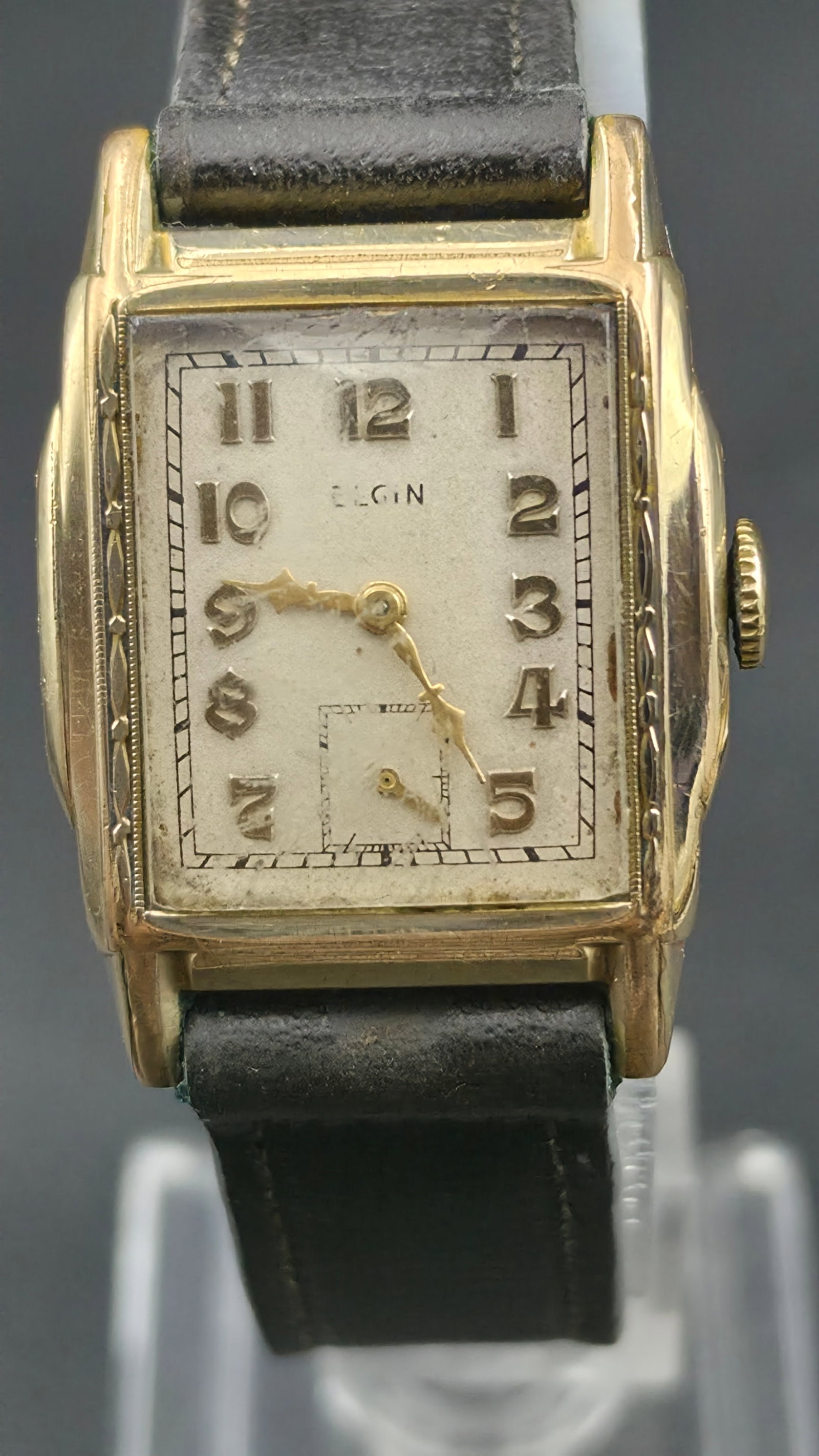 Elgin Art Deco Rectangular Manual Wind 7 Jewel circa 1938 29mm Base Metal Case Runs: This is a vintage circa 1938 Elgin Art Deco manual wind wristwatch with a rectangular cushion-shaped case measuring 29mm as shown by calipers in the photos. The case exterior has engraved Art Deco fol