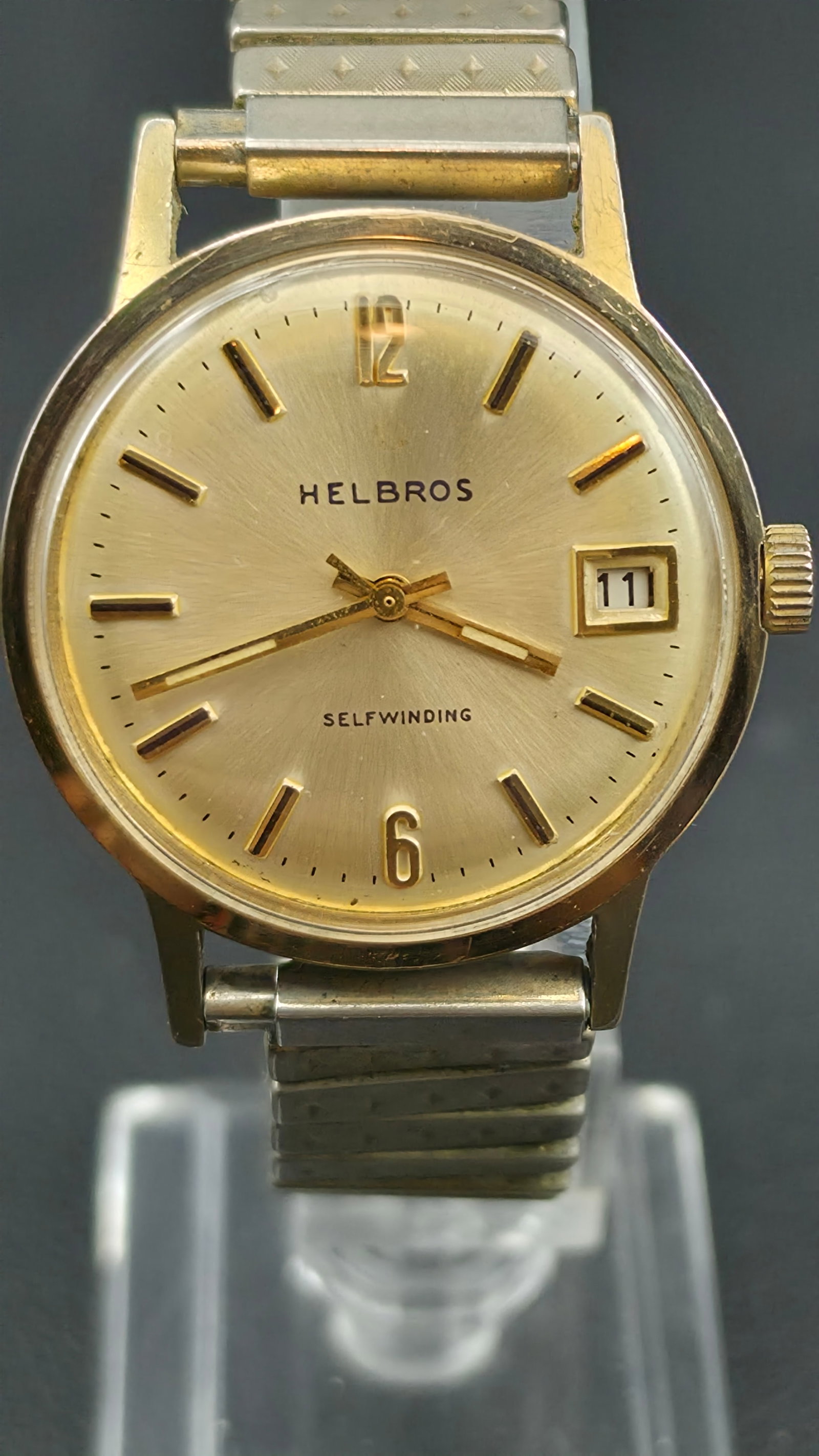 Helbros Selfwinding 25 Jewel Date Automatic 33mm Base Metal Bezel Steel Back Runs: This is a vintage Helbros Selfwinding automatic watch with a gold tone case measuring 33mm as shown by calipers in the photos. The sunburst champagne gold dial has applied gold baton hour markers, Ara