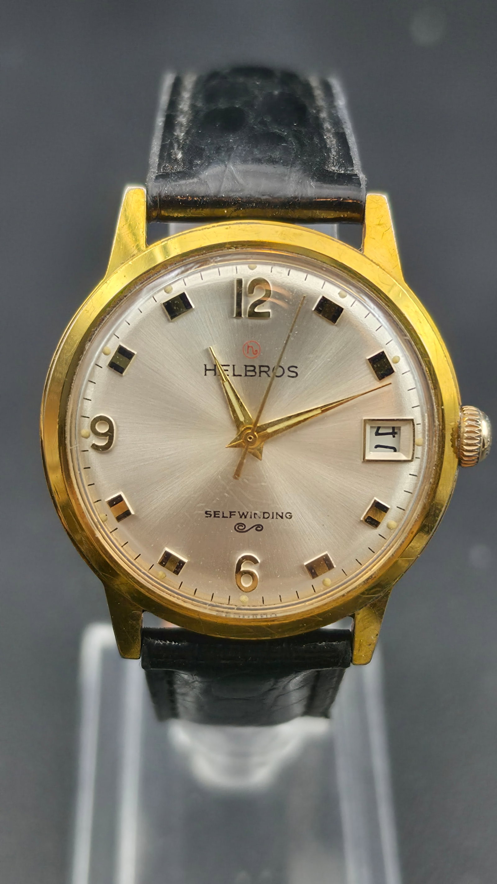 Helbros Selfwinding 17 Jewel Automatic Date Watch 34mm Gold Tone K.M.R. Case Runs: Vintage Helbros Selfwinding automatic wristwatch. The dial reads Helbros with the red Helbros logo above the brand name and Selfwinding with a scroll emblem below center. The silver sunburst radial di
