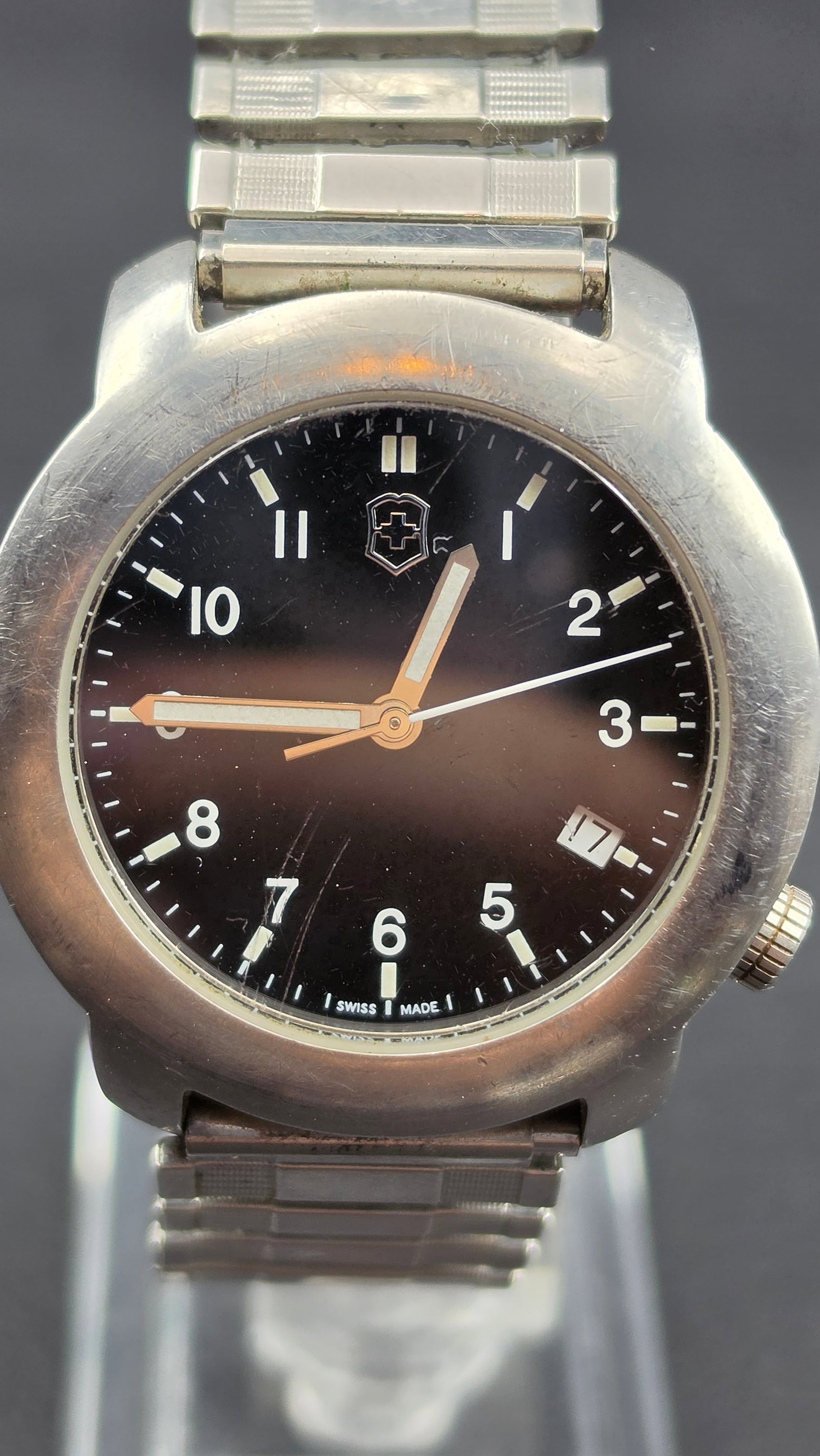 Victorinox Swiss Army V7-00 Basic quartz mens watch all stainless steel 100m water resistant date 37: This is a Victorinox Swiss Army quartz mens wristwatch, model V7-00 Basic. The round all stainless steel case measures 37.31mm and is stamped on the case back with the raised Victorinox shield logo an