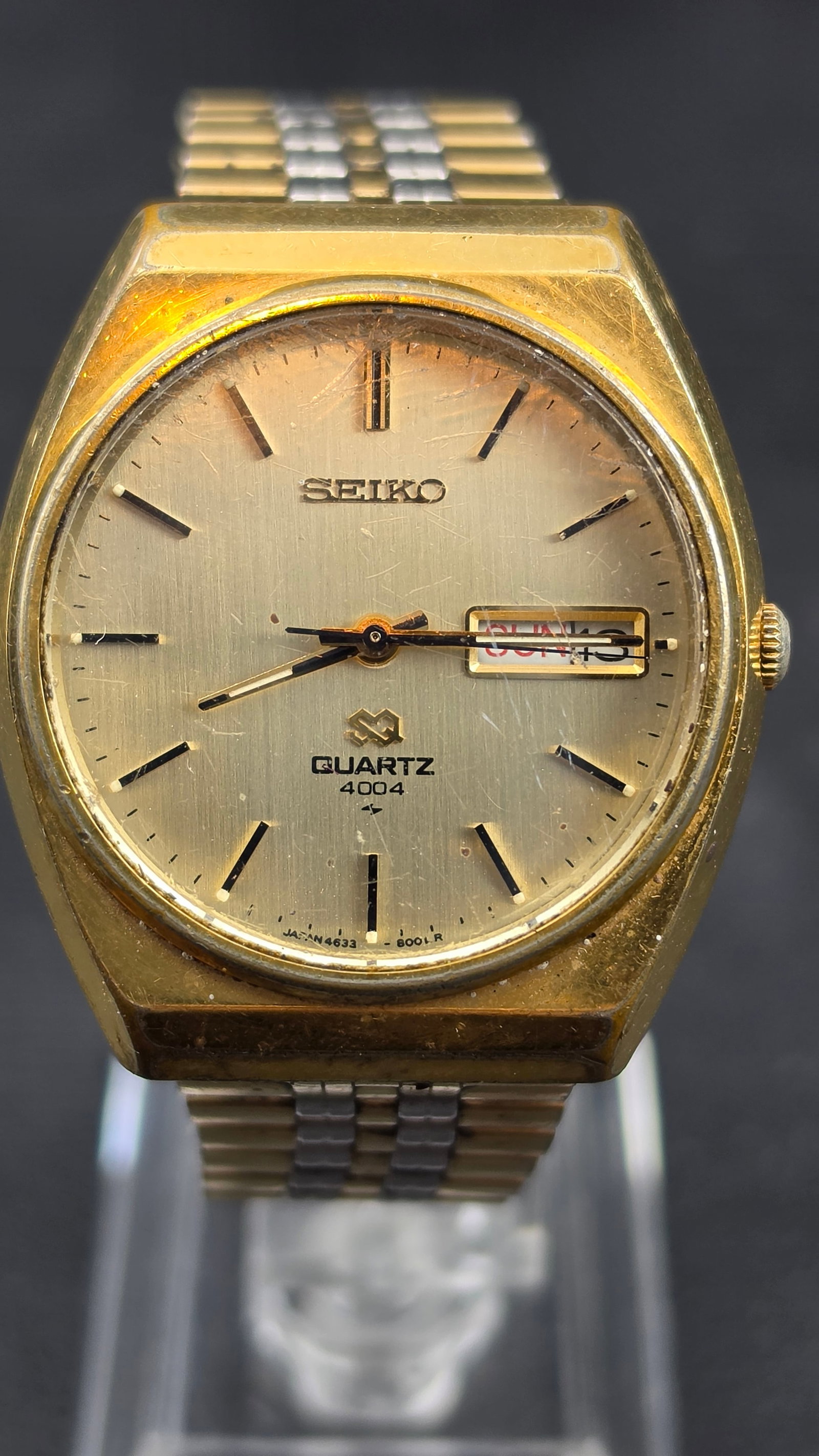 Seiko SQ Quartz 4004 4633-8009 Day Date Gold Tone Two-Tone Bracelet 35.59mm Watch 1976: Vintage Seiko SQ Quartz 4004 wristwatch, model 4633-8009, serial number 690660, indicating production in June 1976. The champagne gold sunburst dial features applied baton hour markers, a minute track