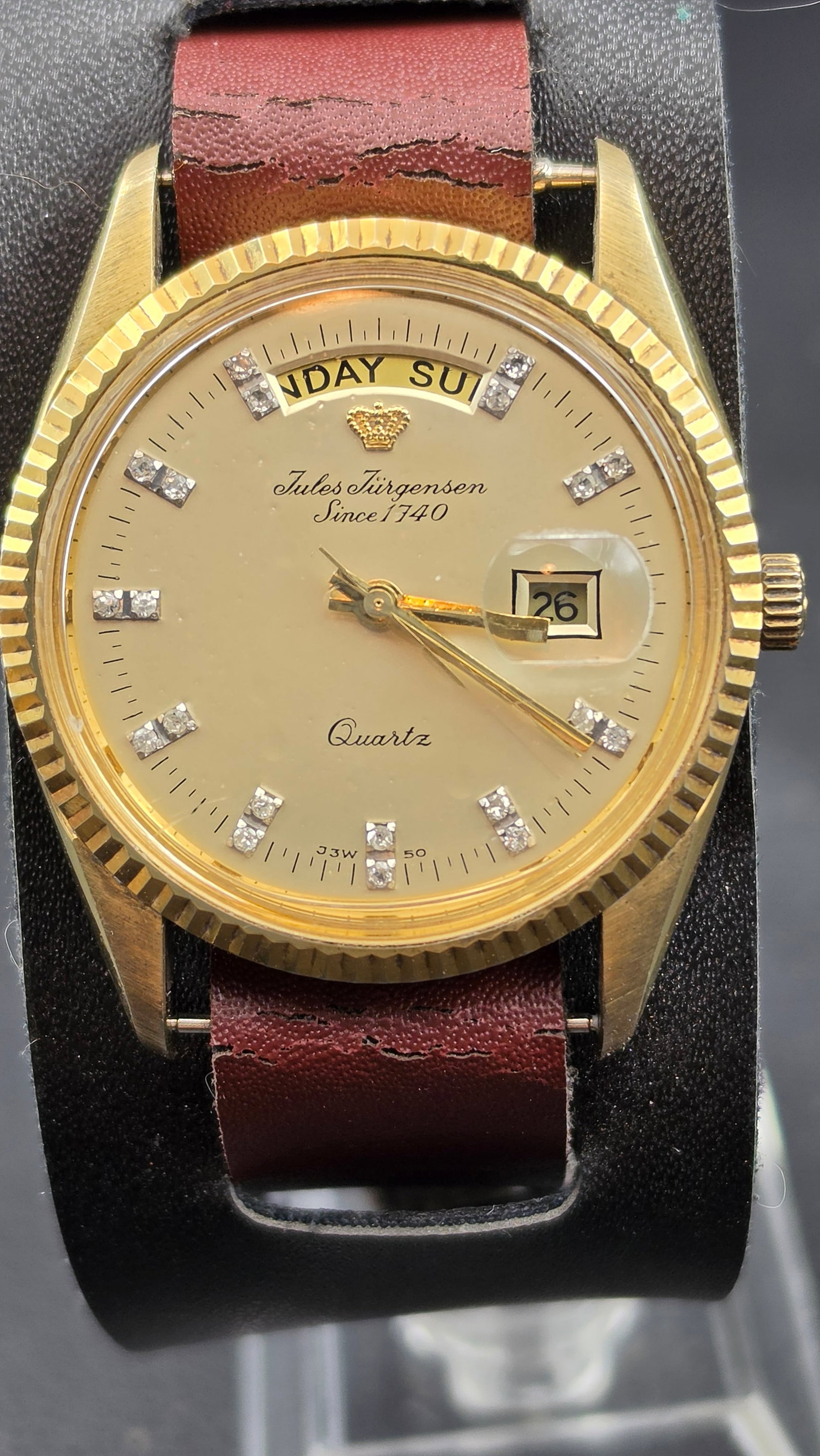 Jules Jurgensen Since 1740 Quartz Day Date CZ Dial Fluted Bezel 35.06mm Watch 1986 New Battery: Jules Jurgensen Since 1740 quartz day and date wristwatch. The champagne dial features paired CZ crystal stone markers at all 12 hour positions, a gold tone crown logo at 12 o'clock, Jules Jurgensen S