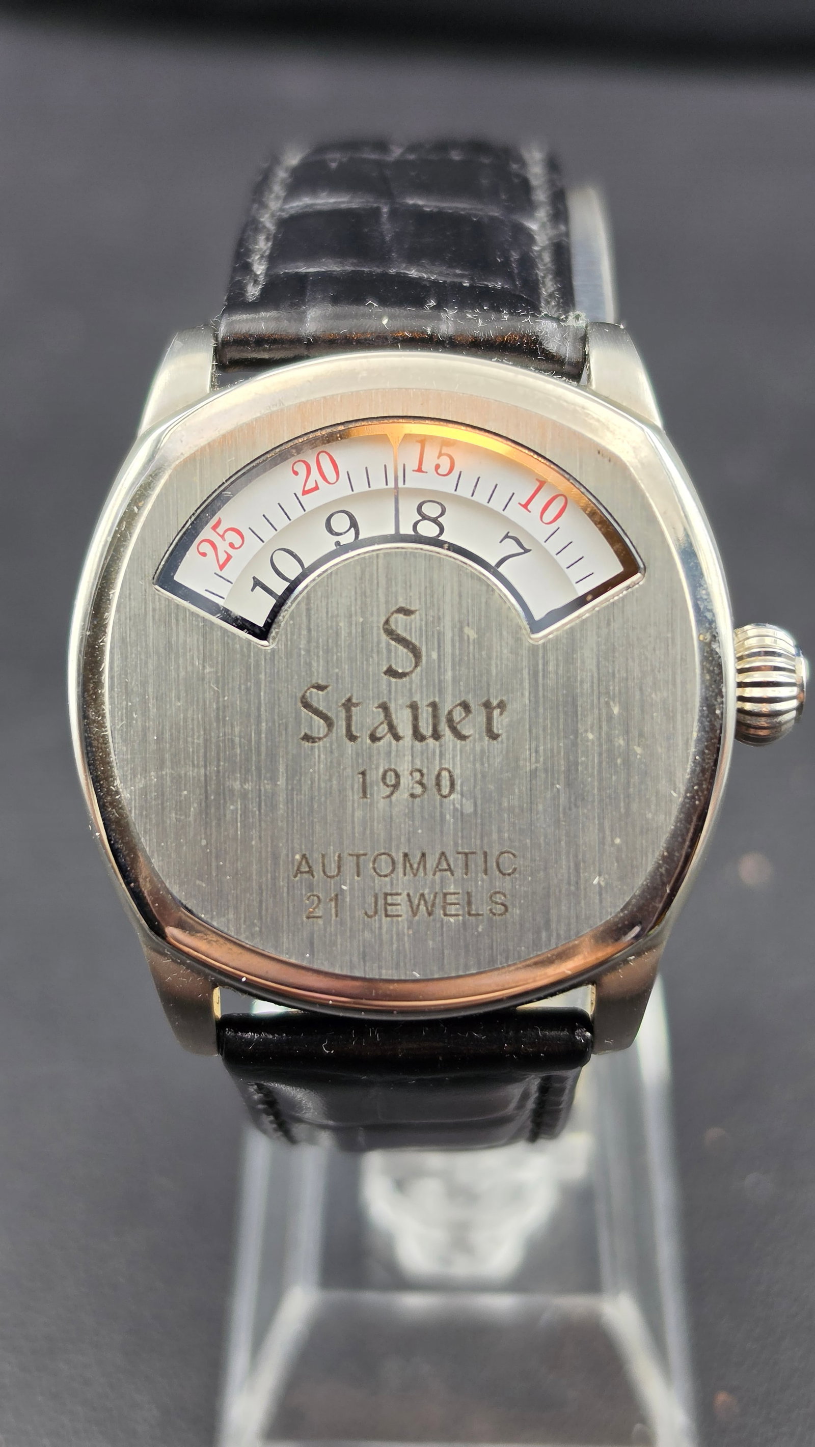 Stauer 1930 Automatic 21 Jewel Jump Hour Retrograde Minute Watch Black Leather Strap with Box: Stauer 1930 automatic wristwatch with 21 jewel movement. All stainless steel cushion-shaped case, 3ATM water resistant. The dial features a retrograde jumping hour and minute display through a semi-ci