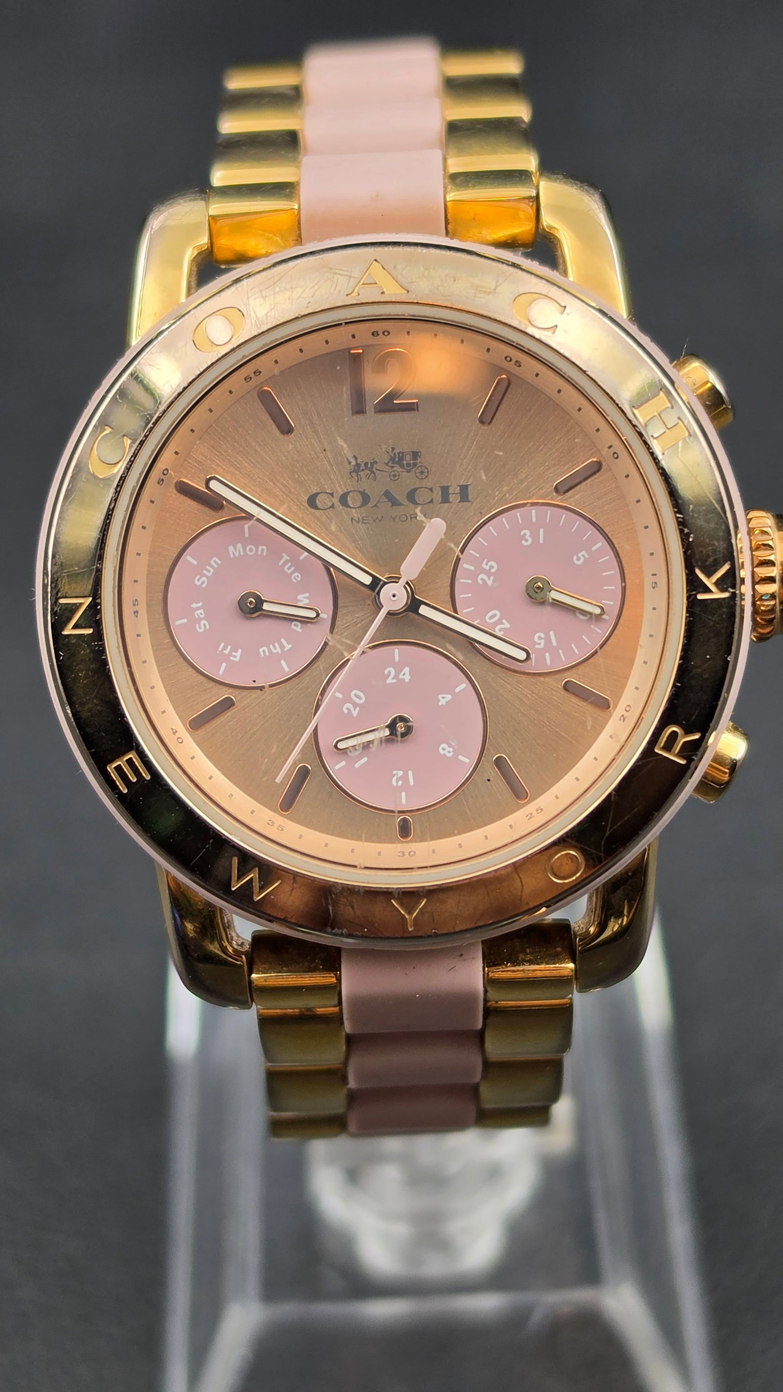 Coach New York Chronograph Ladies Watch Gold Tone Pink Bracelet CA.04.7.44.1246 34mm: This is a Coach New York ladies chronograph wristwatch. The rose gold sunburst textured dial features the Coach horse and carriage logo above Coach New York printed in the upper half. Applied gold-ton