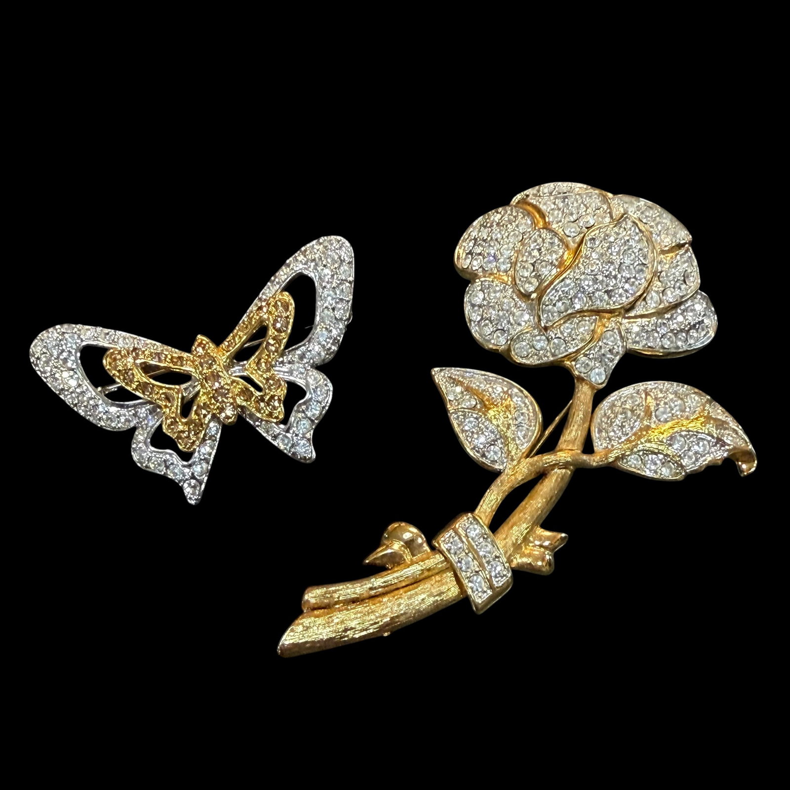 2 Vintage Silver Gold Tone Brooch Pins Nolan Miller Rose Butterfly Rhinestone: Maker: Rose, Nolan Miller. Butterfly unmarked. / Material: Gold tone and silver tone base metal. / Stone: I believe they are rhinestones. / Size: Rose 3 5/8” x 2 1/4”. Butterfly 2 1/16&rdq