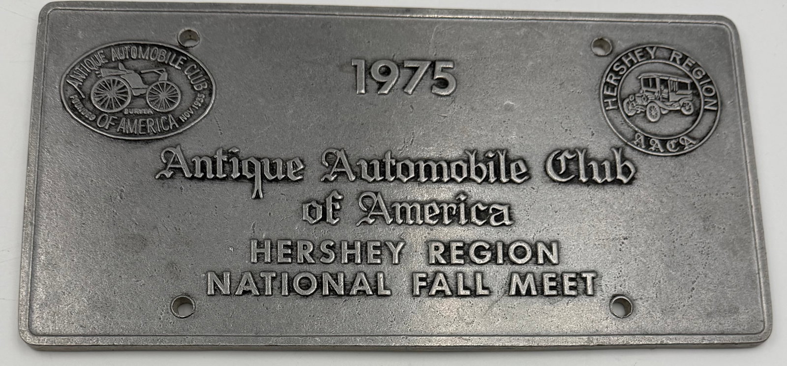 1975 AACA Hershey Region National Fall Meet Metal Plate Sign: Vintage 1975 Antique Automobile Club of America (AACA) Hershey Region National Fall Meet commemorative metal plate/sign. Features raised embossed lettering with classic antique automobile club emblems