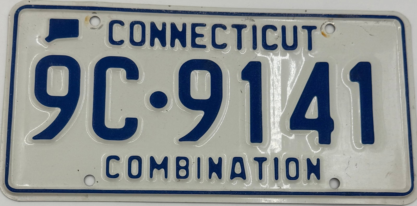 Vintage Connecticut Combination License Plate 9C-9141: Original vintage Connecticut “Combination” license plate featuring number 9C-9141. White embossed steel plate with blue lettering and border, showing light wear, minor scratches, and age-relat
