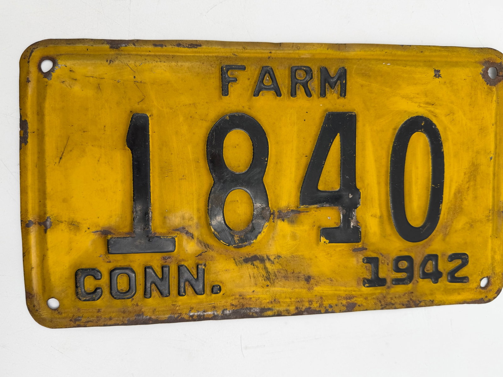 1942 Connecticut Farm License Plate 1840: Original 1942 Connecticut FARM license plate with embossed black numbers on yellow background. Vintage plate displays authentic wear, scratches, rust spots, and aged patina from years of use. A great 