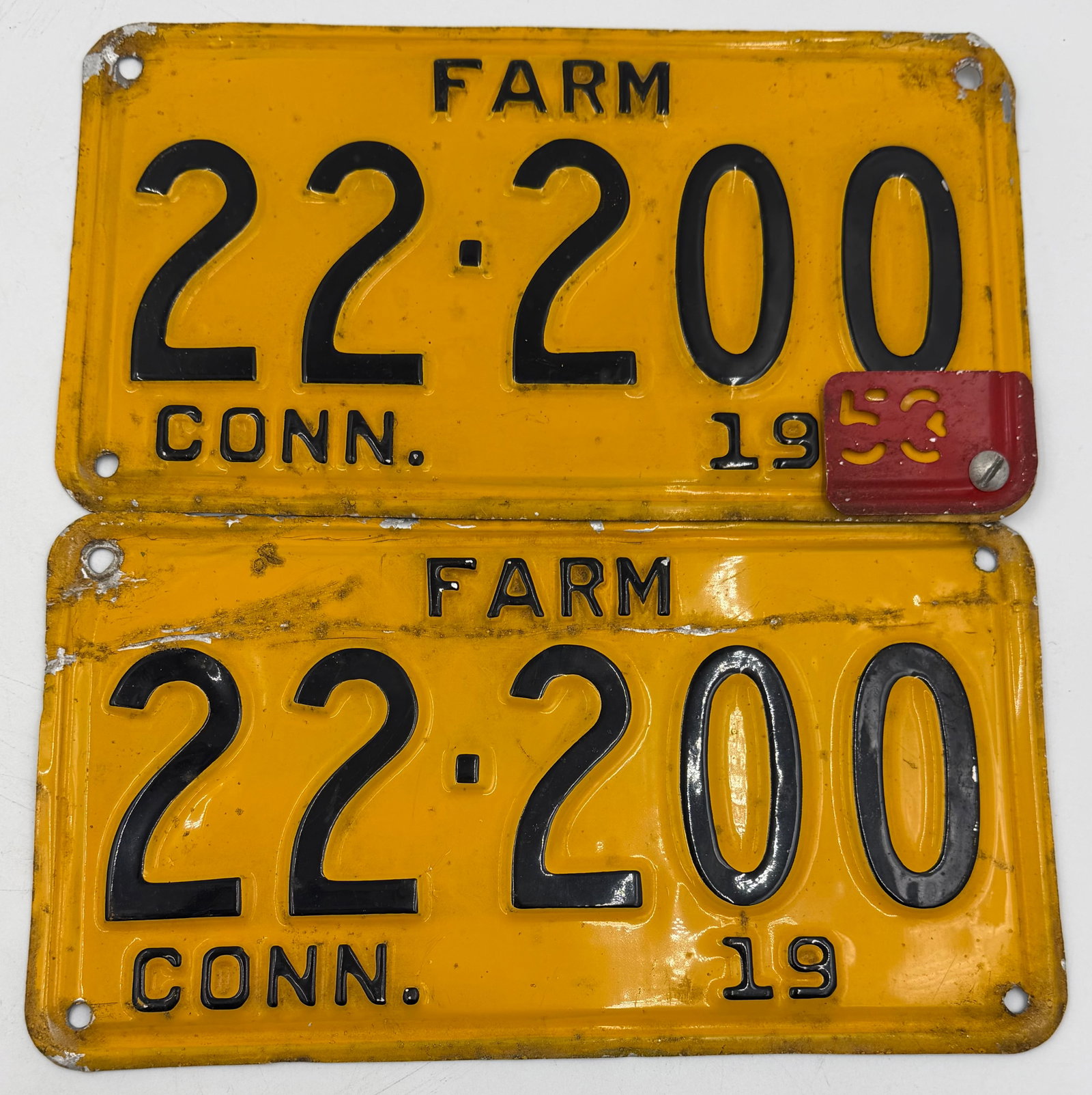 1953 Connecticut Farm License Plate Pair 22-200: Matching pair of original 1953 Connecticut FARM license plates numbered 22-200, featuring embossed black numbers on yellow background with original 1953 metal tab attached. Nice vintage set with age w