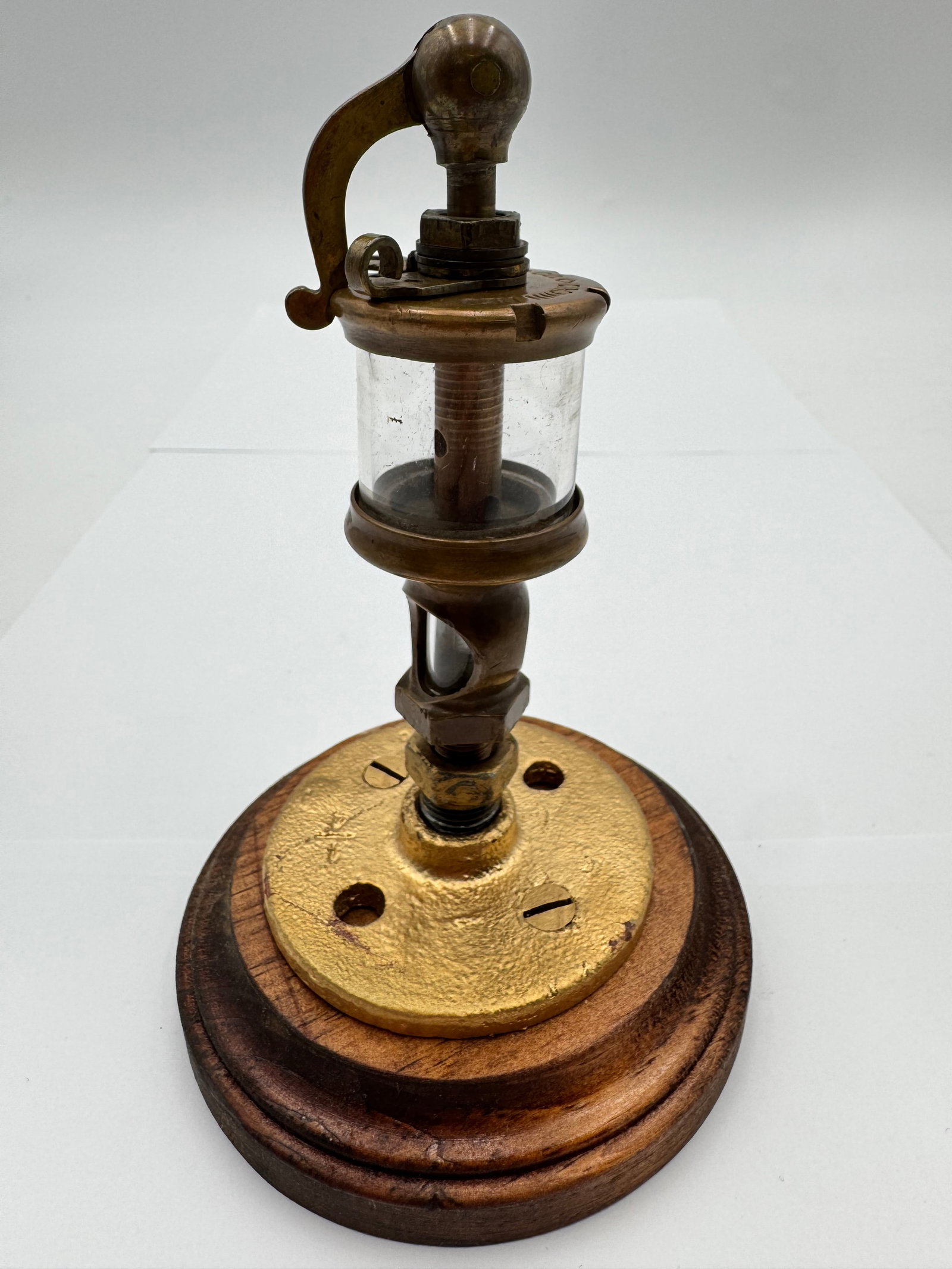 Antique Lunkenheimer Crown No. 0 Brass Steam Engine Oiler Lubricator on Wood Base: Antique Lunkenheimer “Crown No. 0” brass steam engine lubricator/oiler mounted on a wood display base. Features a clear glass reservoir, heavy brass construction, and the distinctive Lunkenhei