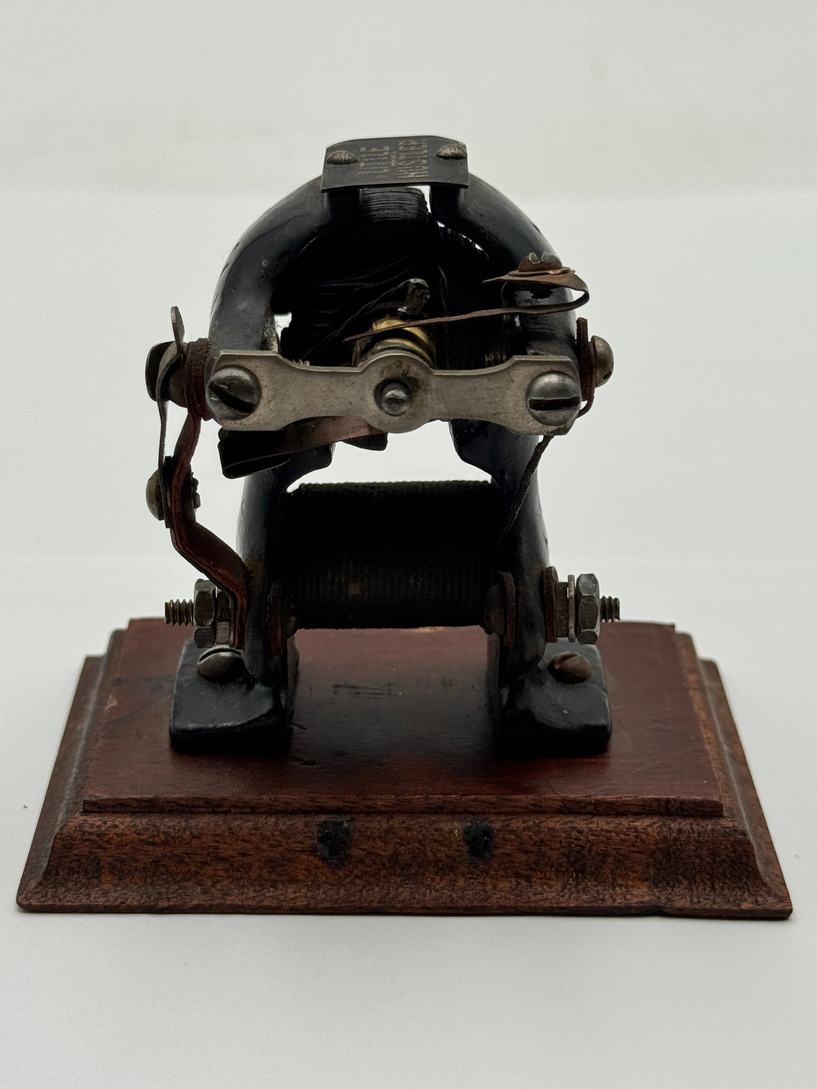 Antique Little Hustler electric motor on Wood Base: Original antique “Little Hustler” electric motor mounted on an original wood base. This early electrical communication device features exposed copper windings, cast metal construction, adjusta