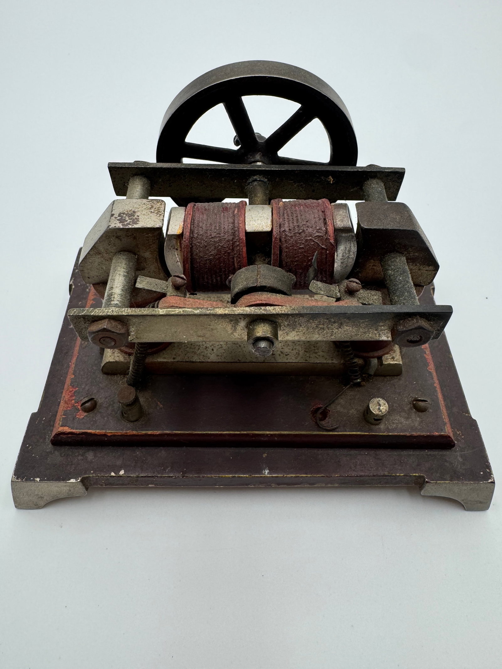 Antique Early Electric Motor Dynamo Physics Laboratory Apparatus c.1900: Antique electromagnetic motor or dynamo demonstration apparatus featuring dual wrapped armature coils, cast iron flywheel, exposed electrical contacts, and heavy metal base. Likely used in physics