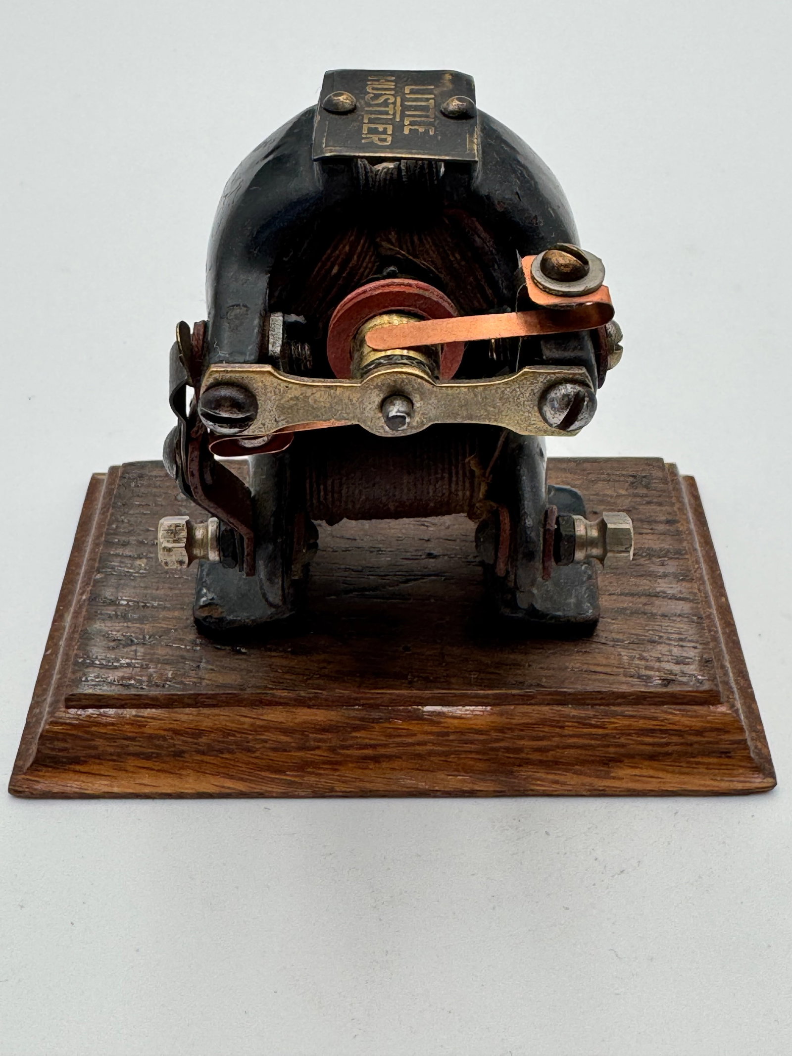 Antique LITTLE HUSTLER Educational Electric Motor Laboratory Device: Rare antique “LITTLE HUSTLER” toy electric motor dating to the early 1900s, featuring a cast iron housing mounted on its original wooden base. This early electromagnetic motor includes