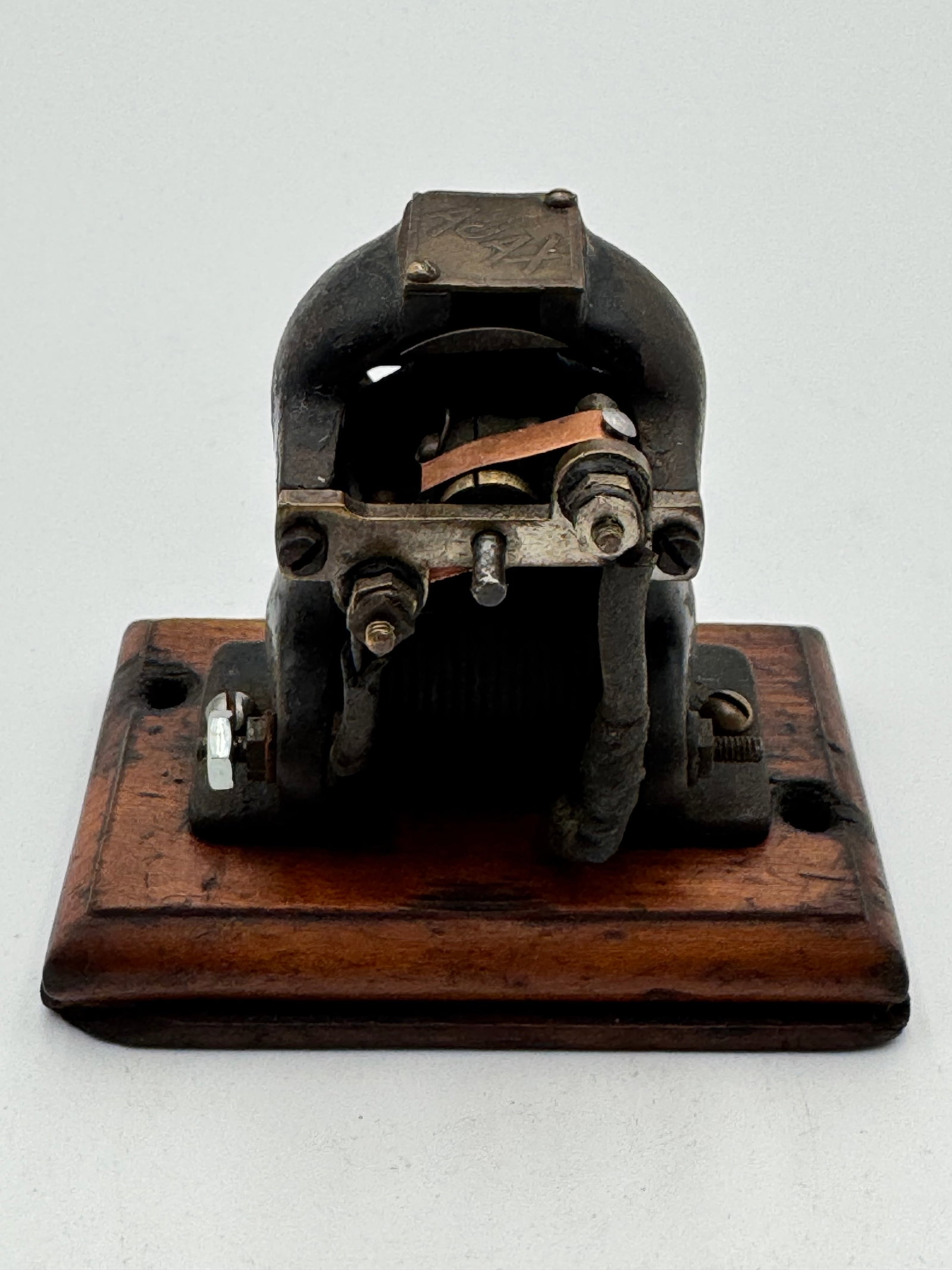 Museum Quality AJAX Early Electric Motor on Original Wood Base: Rare antique AJAX toy electric motor dating to the early 1900s. Features a heavy cast iron body mounted on its original wooden base with exposed electromagnetic components and original contact assembl