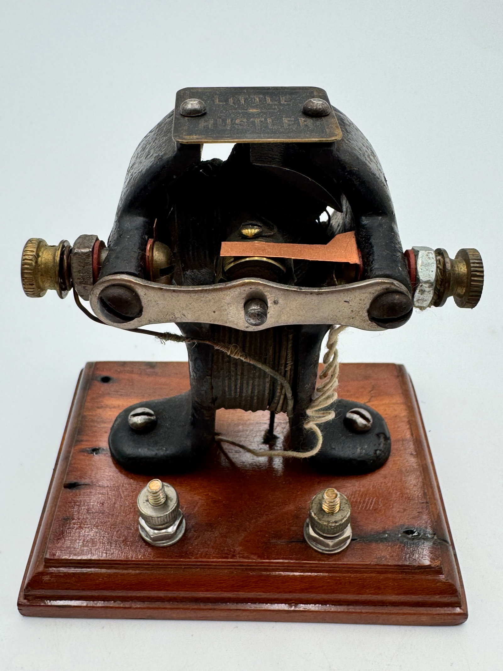 Rare Antique “Little Hustler” Electric Motor Scientific Demonstration Toy Motor: Original antique “Little Hustler” electric motor mounted on a wood base with exposed copper contact and early electromagnetic construction. Features cast iron frame, original maker plate, and 