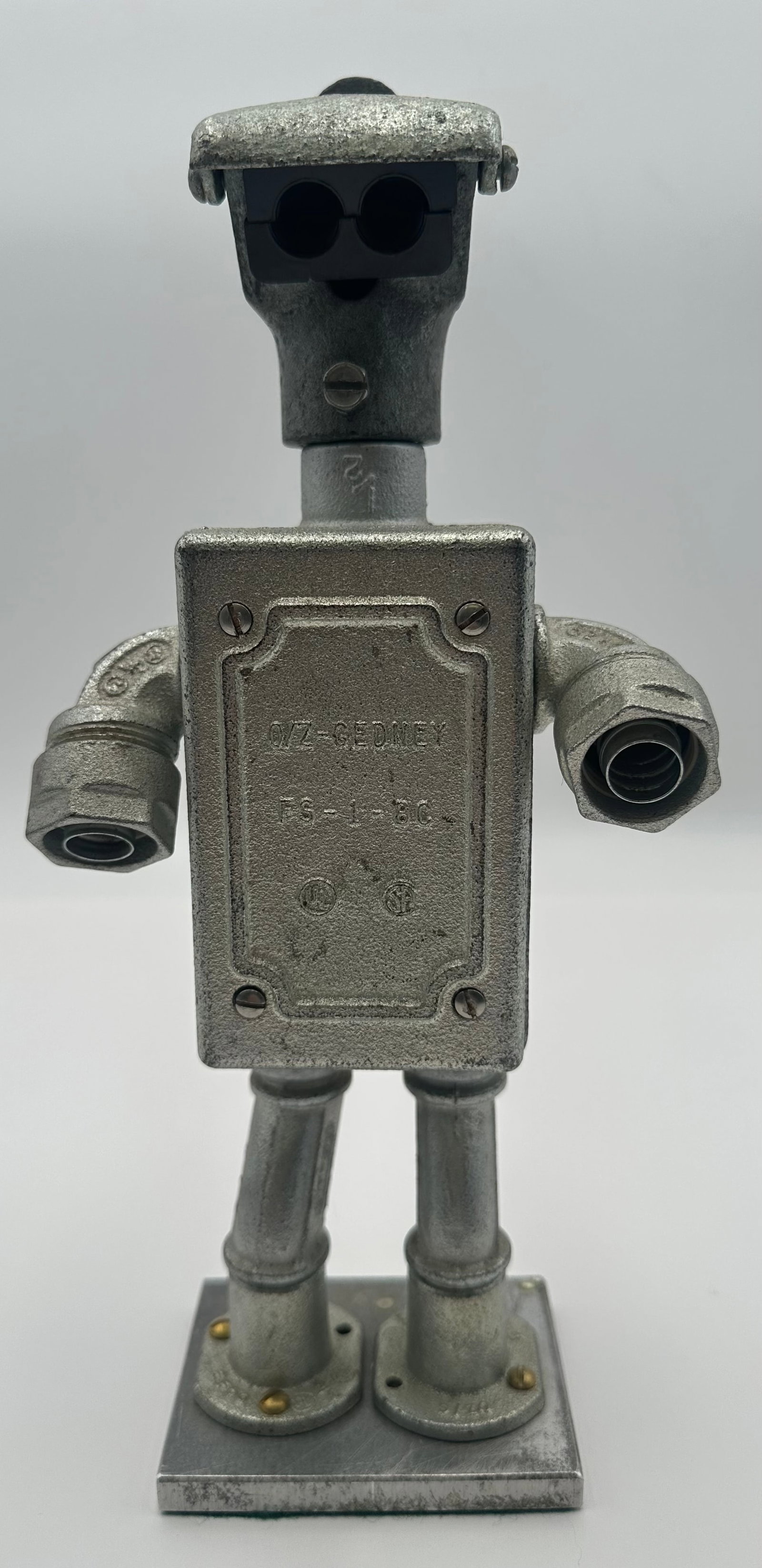 Industrial Junk Art Robot Sculpture Made From O-Z/Gedney Electrical Parts: Unique handmade robot sculpture created from authentic O-Z/Gedney industrial electrical conduit and junction box components, including an FS-1-BC cast cover. Constructed from heavy cast metal electric