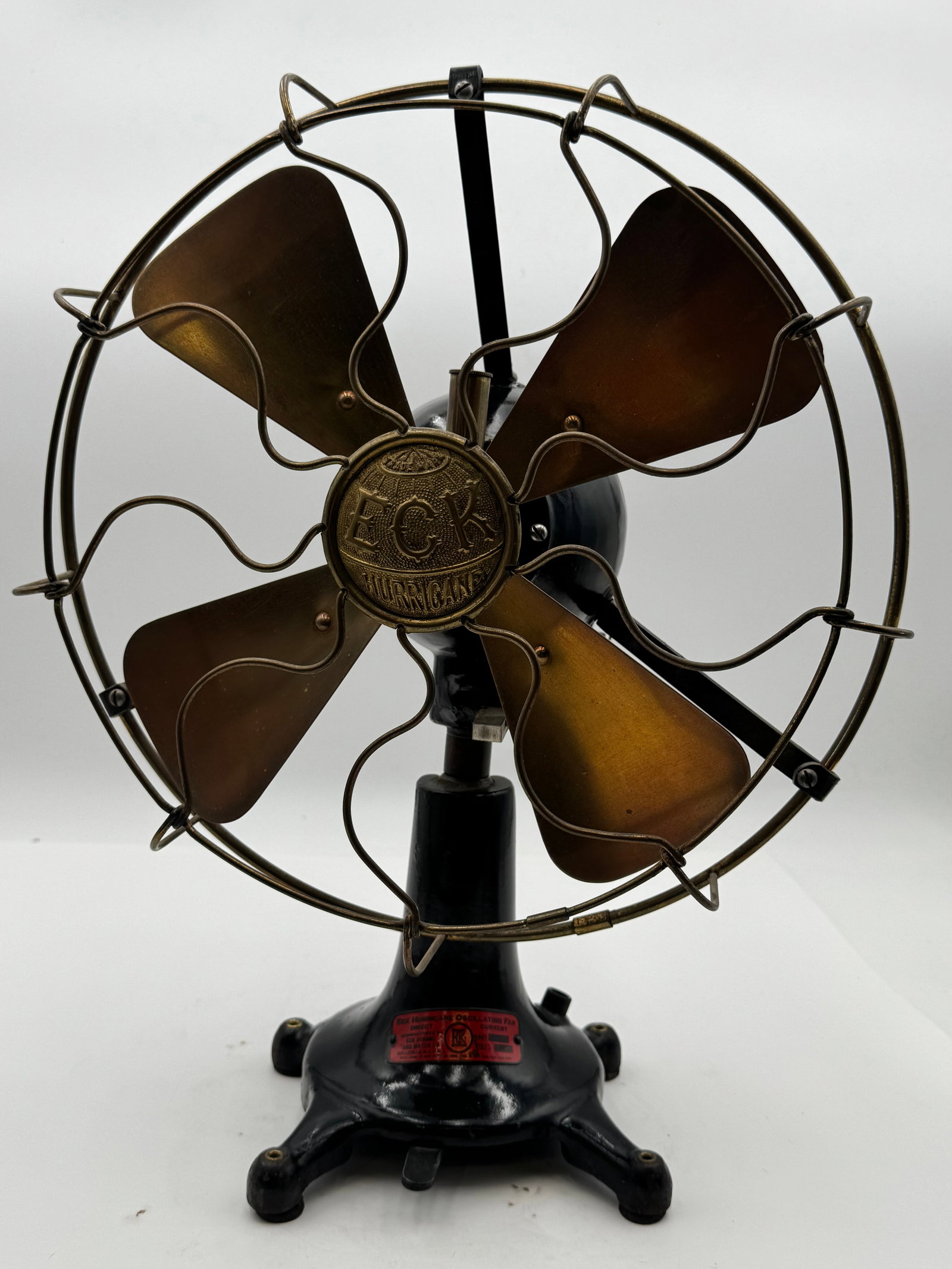 Antique ECK Hurricane Oscillating Brass Blade Fan Bellville NJ: Exceptional early 1900s ECK Hurricane Oscillating Fan featuring original brass blades, cast iron base, and highly desirable exposed brass oscillation gearbox. Retains original red manufacturer tag mar