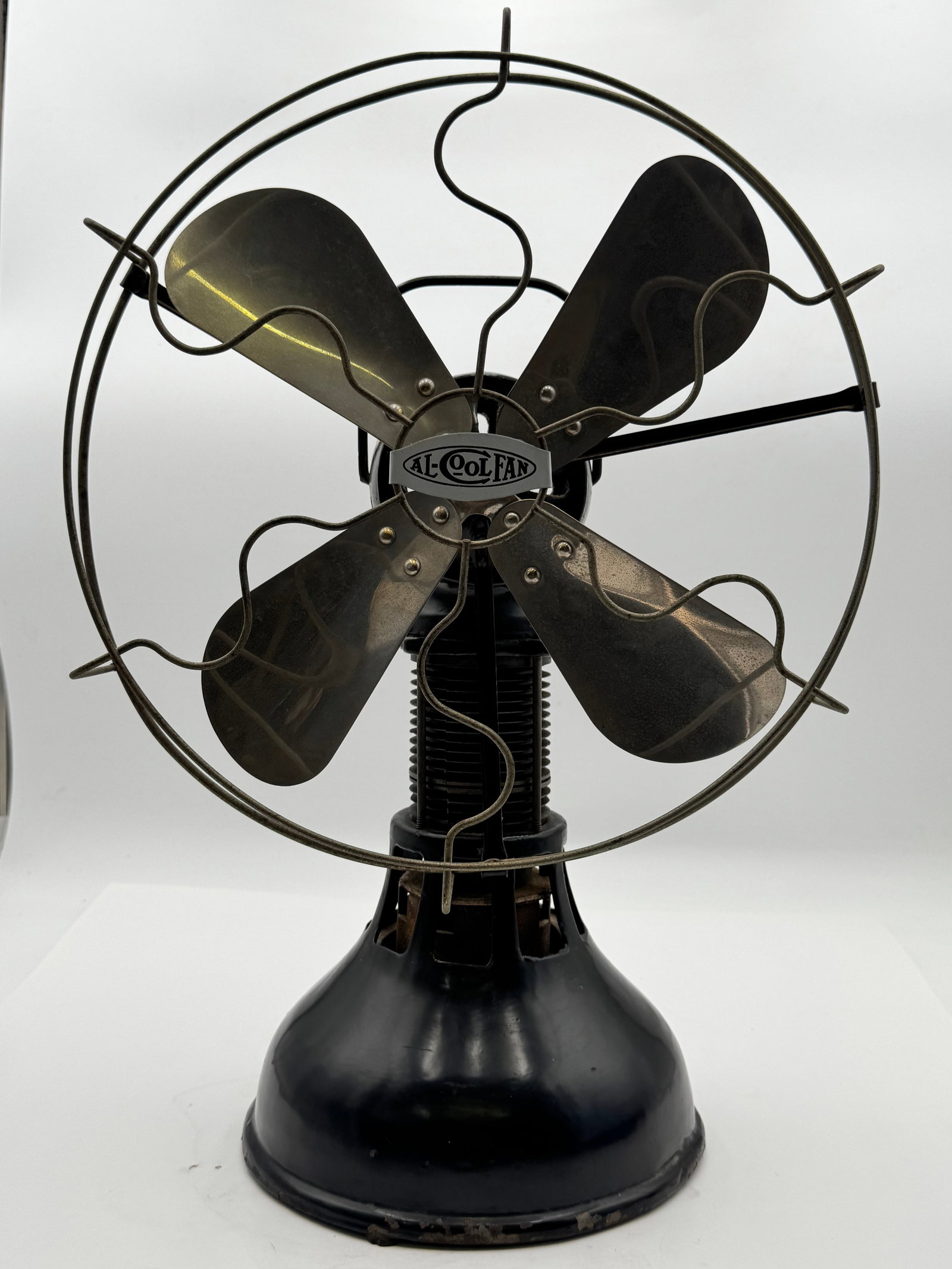 Antique Al-Cool Fan Brass Blade Electric Desk Fan Art Deco: Rare antique Al-Cool Fan featuring four brass blades, open wire safety cage, and heavy cast iron base with distinctive stepped Art Deco styling. Retains original “AL-COOL FAN” center badge and