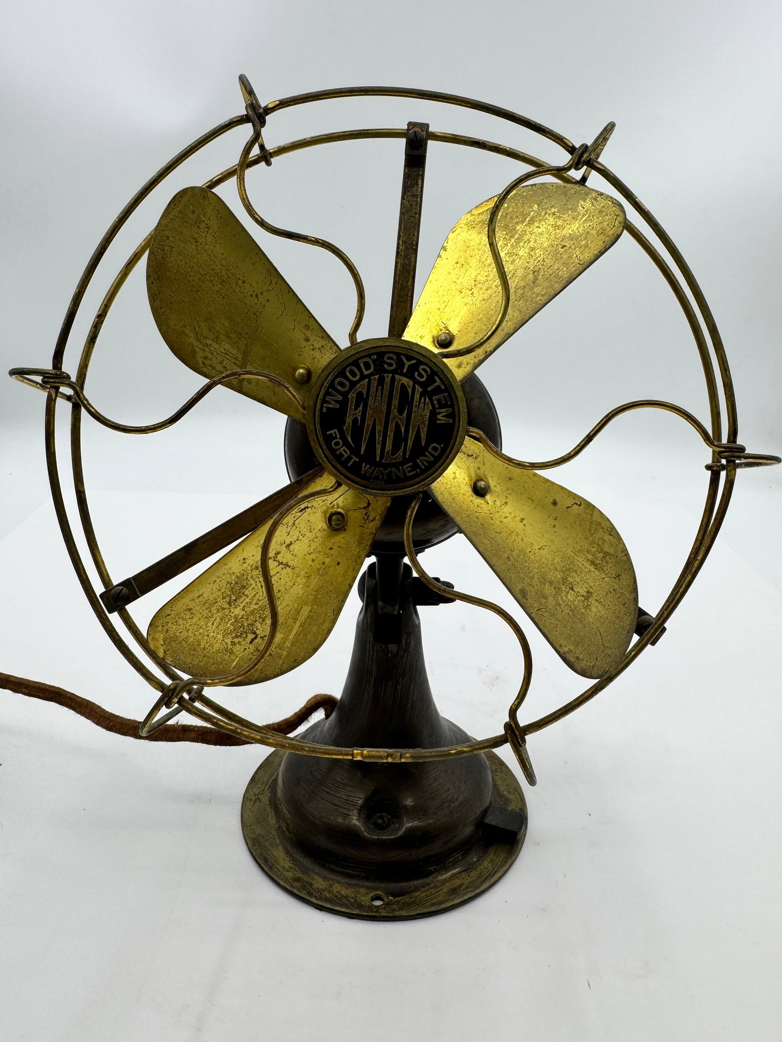 Antique Wood System Fort Wayne Electric all Brass Blade Desk Fan: Antique Wood System A.C. fan motor manufactured by Fort Wayne Electric Works, Fort Wayne, Indiana. Features four brass blades, ornate brass wire cage, and black cast iron base with original “Wood Sy