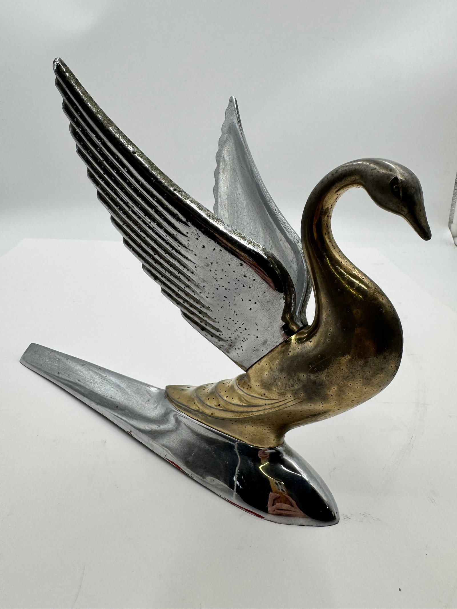 Vintage Flying Swan Hood Ornament Chrome Brass Auto Mascot: Vintage chrome and brass-tone flying swan hood ornament featuring raised wings and streamlined Art Deco styling. Heavy cast metal automotive mascot with polished silver-tone base and gold-tone swan bo