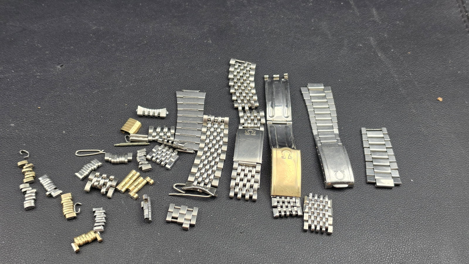 Vintage Omega Bracelet Lot Ref 1039 Steelinox Clasp Dated 3/70 + 14KGF + Links Parts Speedmaster: This lot is a mixed collection of genuine Omega-signed bracelet hardware, links, and parts, the most notable piece being an original Omega reference 1039 Steelinox fold-over clasp stamped "Steelinox /