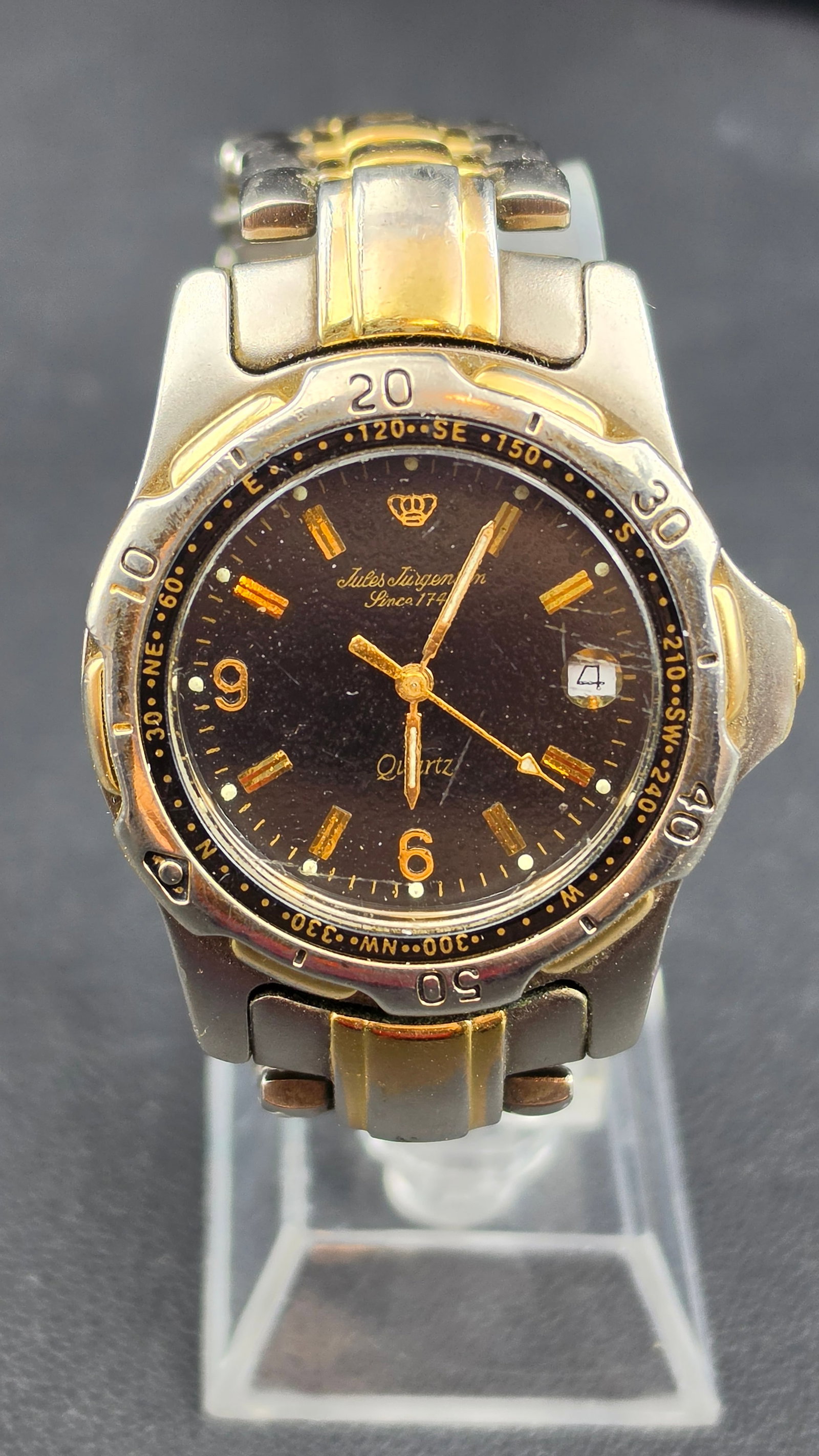 Jules Jurgensen Since 1744 Two-Tone Quartz Sport Watch Compass Bezel Date Ref 7619 c. 1980s–1990s: This is a vintage Jules Jurgensen quartz sport-style wristwatch, reference 7619, featuring a rotating compass directional bezel and dating to the 1980s to early 1990s. The case back is stamped Base Me
