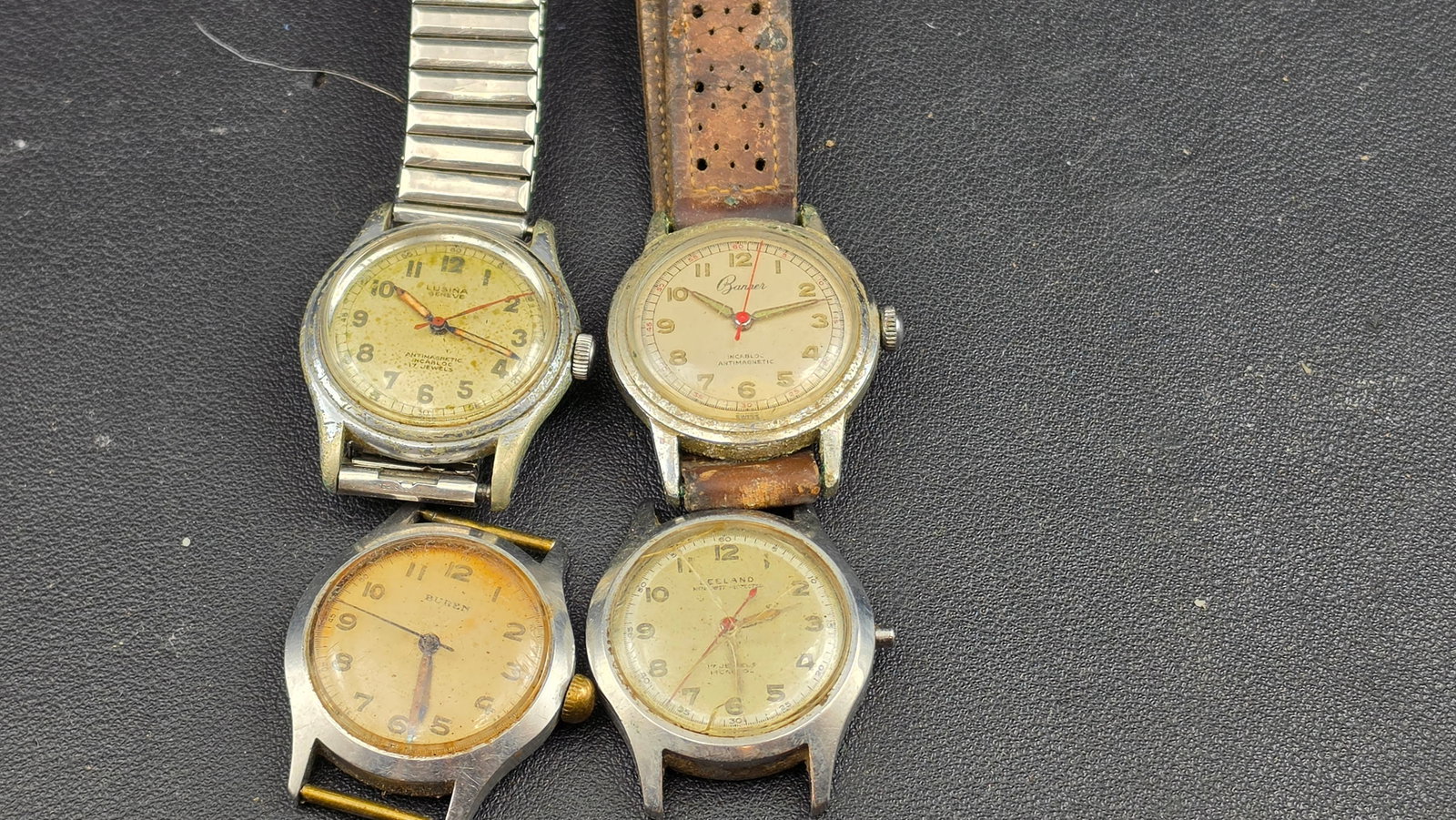 Lot of 4 Vintage Swiss Men's Military Style Watches Lusina Buren Banner Leeland Incabloc: This lot brings together four vintage Swiss-made men's mechanical wristwatches in the military field-watch style that dominated the post-World War II civilian market, sold together as a single group. 