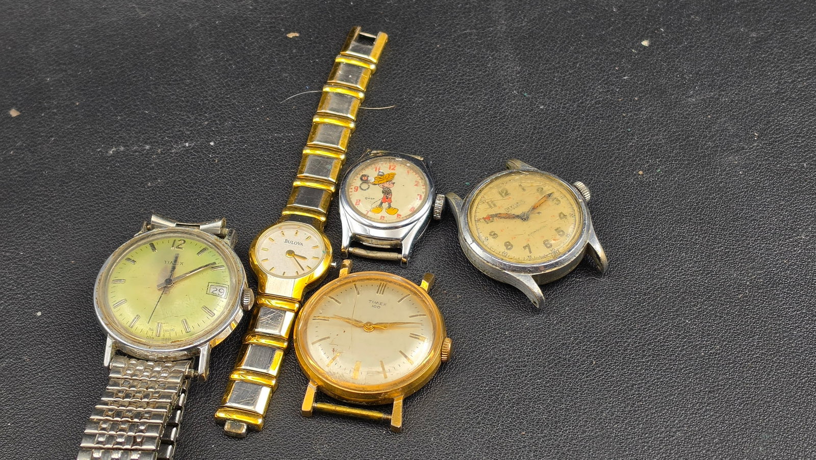 Lot of 5 Vintage American & Swiss Watches: Timex, Bulova, Mickey Mouse WDP c.1940s–1980s: This mixed lot of five vintage timepieces spans roughly four decades and offers a range of styles from mid-century Swiss field watches to American novelty collectibles. The standout piece is the Micke