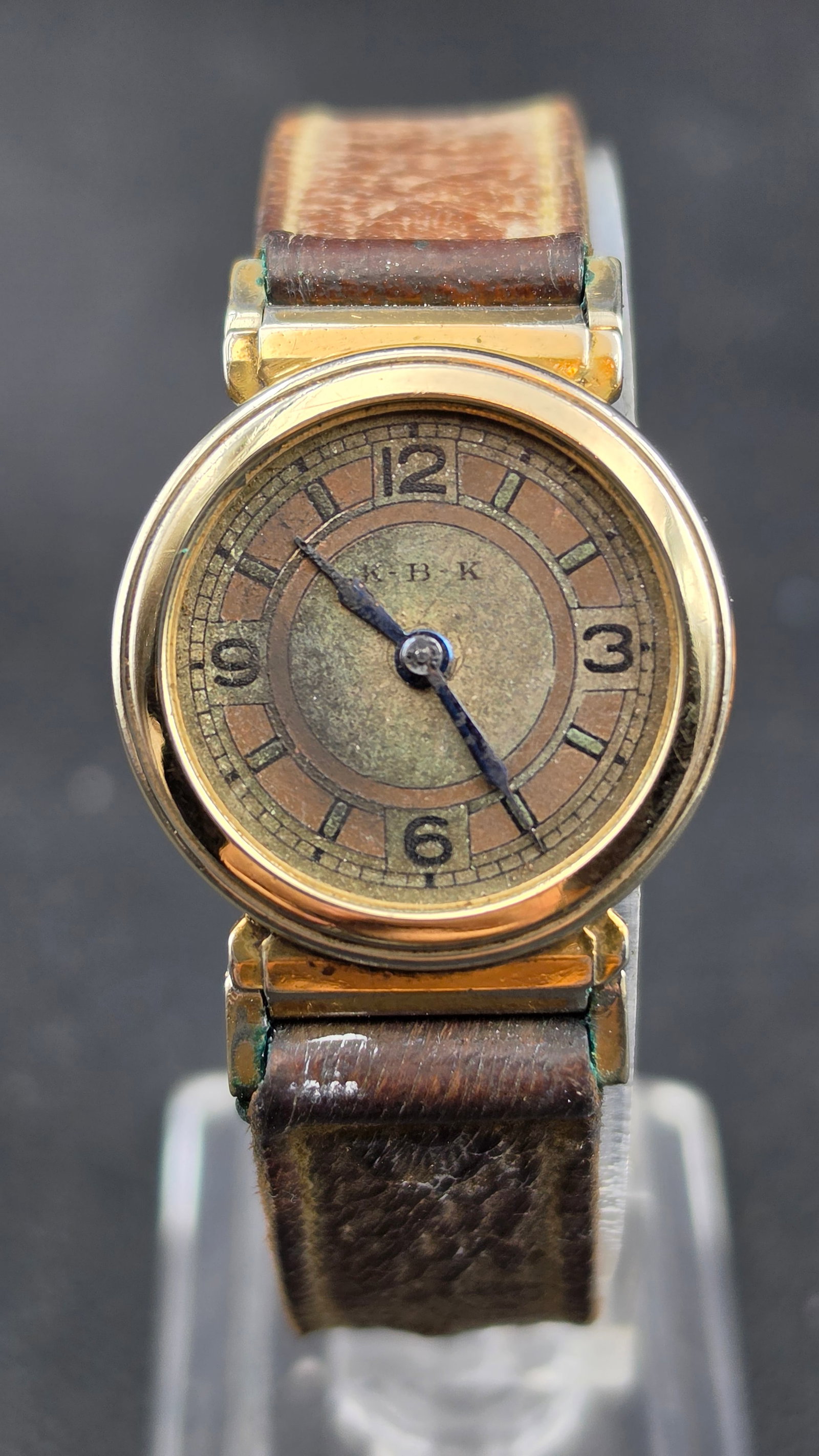 Antique 1920s K·B·K Swiss 15 Jewel 10K Rolled Gold Plate Trench Style Wristwatch 27mm: Up for sale is a charming antique Swiss manual-wind wristwatch dating to the 1920s. The round 10K rolled gold plate case measures approximately 27mm wide and features the distinctive hinged swivel lug