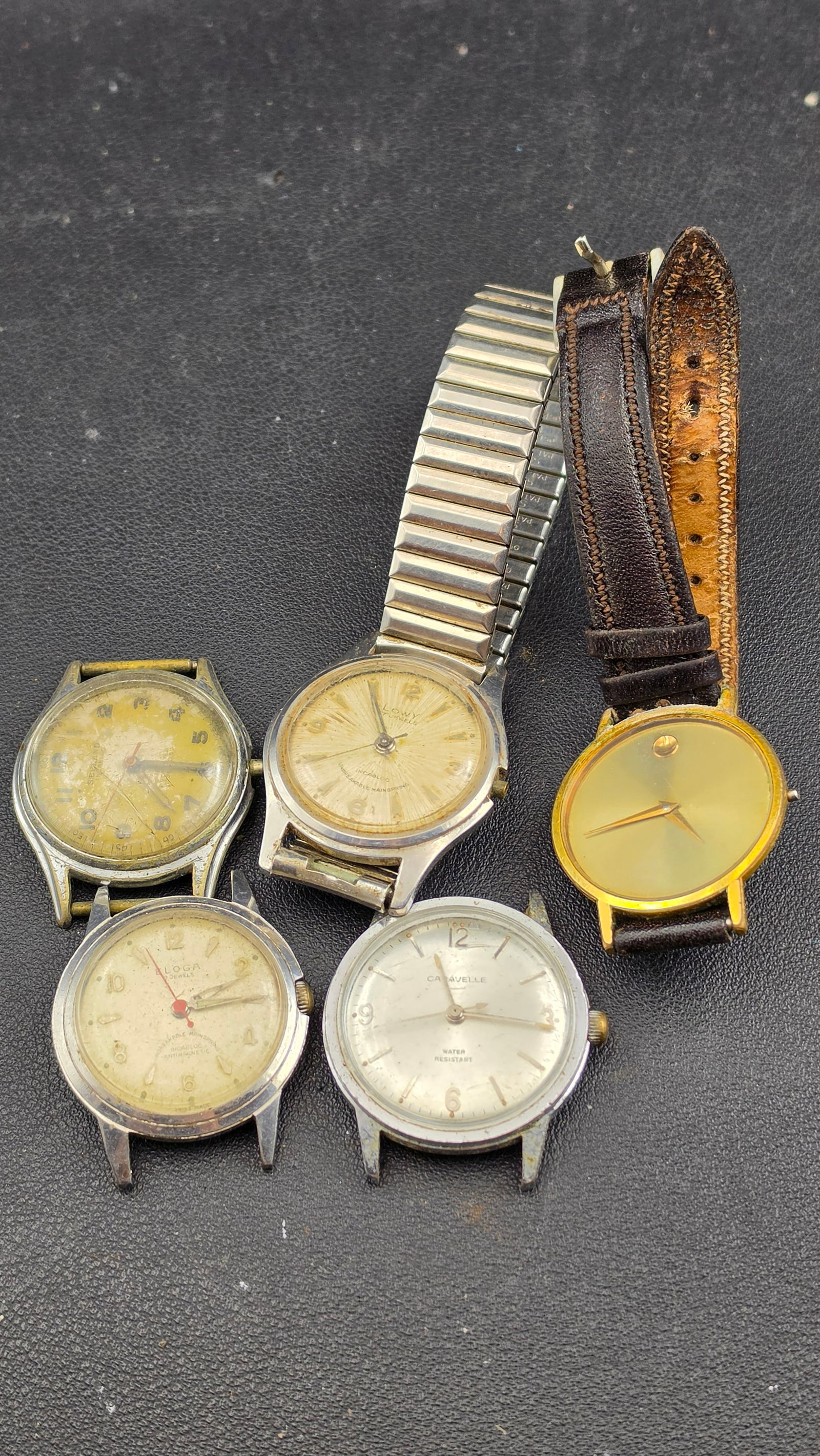 Lot of 5 Vintage Swiss Manual Wind Watches + Movado Museum Quartz Parts Repair 1950s–1980s: Up for sale is a lot of five vintage watches offered for parts, repair, or display. The standout piece is a Movado Museum quartz in a gold-tone case with the iconic minimalist dial featuring a single 