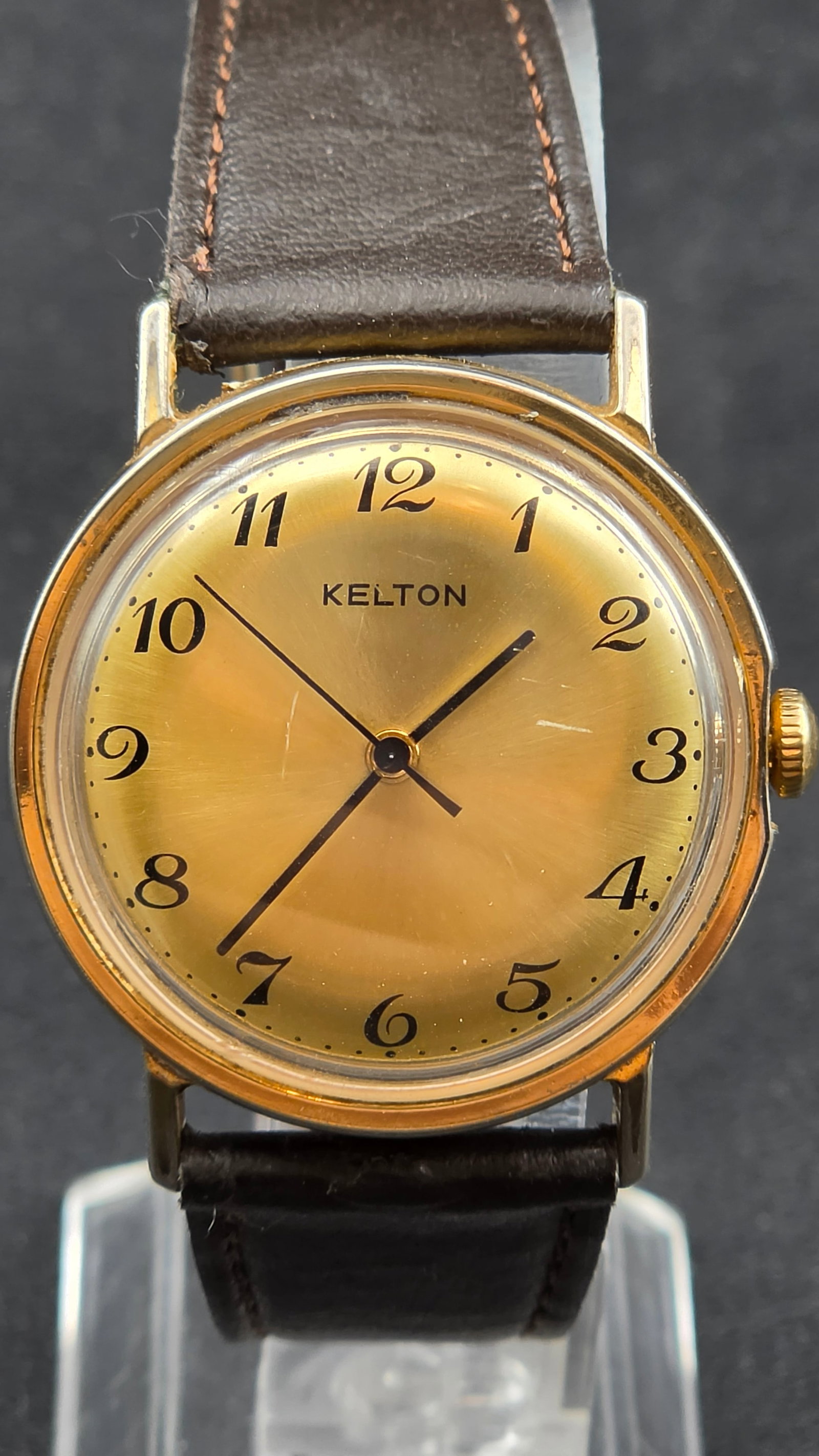 Vintage 1970s Kelton by Timex France Mechanical Watch Gold Tone Arabic Dial 34mm Leather Strap: Up for sale is a vintage Kelton mechanical wristwatch from France, dating to the 1970s. Kelton was the French market trade name used by Timex, born out of a partnership with Besançon watchmaker Stép