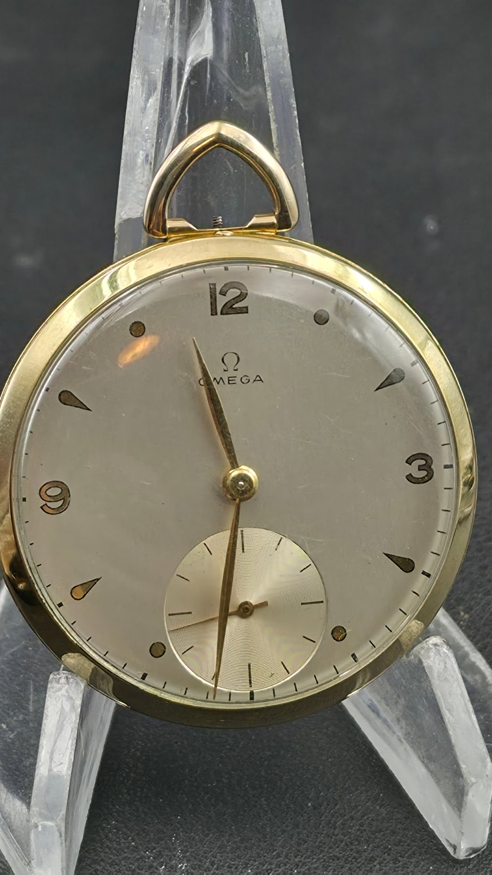 Vintage 1945 Omega 17 Jewel Pocket Watch 14K Gold Filled Wadsworth Case 43mm Sub-Seconds: This is a vintage circa 1945 Omega open-face pocket watch housed in a 14K gold-filled Wadsworth case measuring approximately 43mm in diameter. The case back is stamped with the Omega logo alongside th