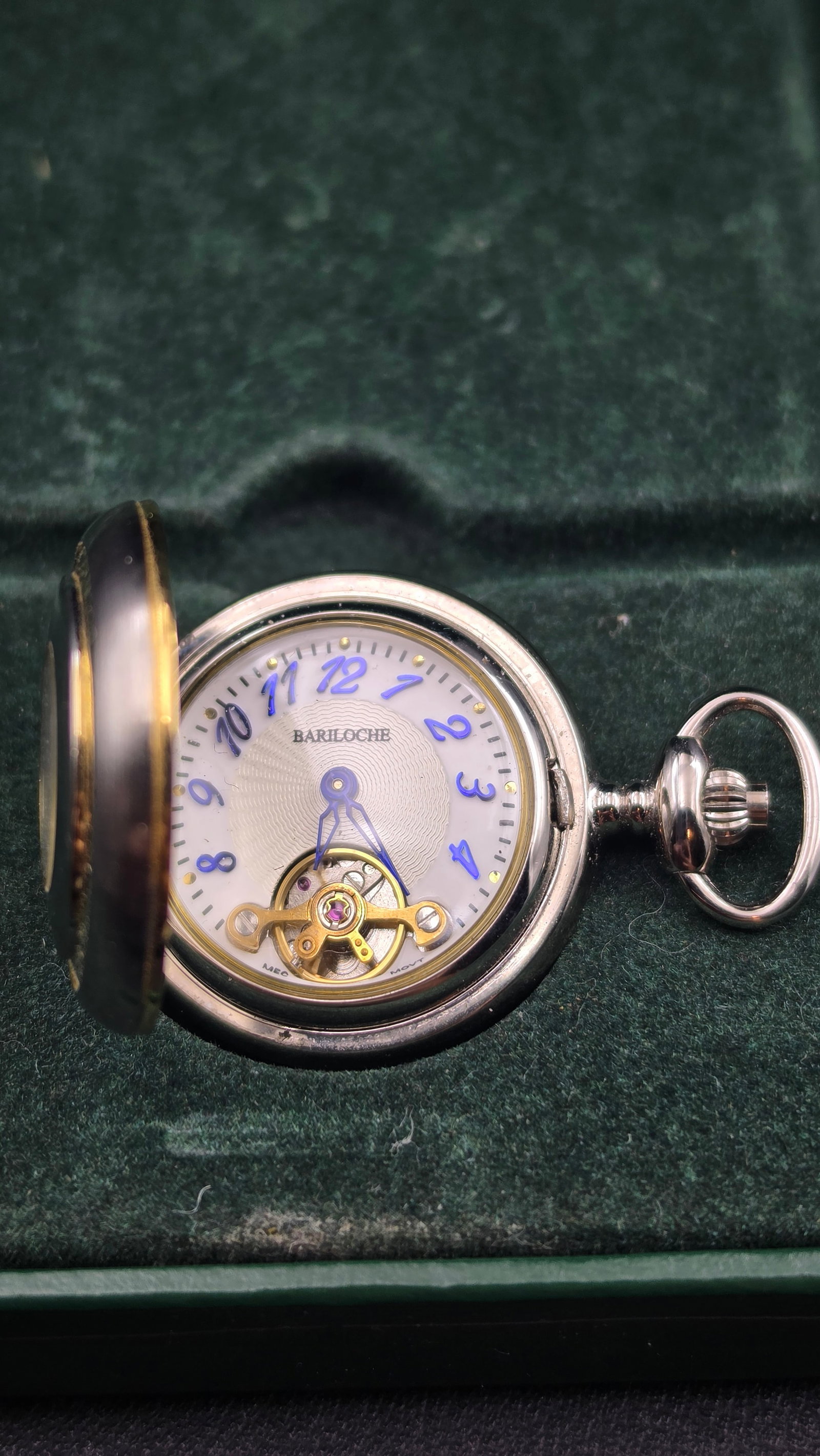 Bariloche Open Heart Mechanical Pocket Watch 17 Jewel Hunter Case NOS w/ Box Runs: This is a Bariloche mechanical open-heart pocket watch, new old stock, complete in its original green Bariloche-branded presentation box. The white guilloché-style dial features blue Arabic