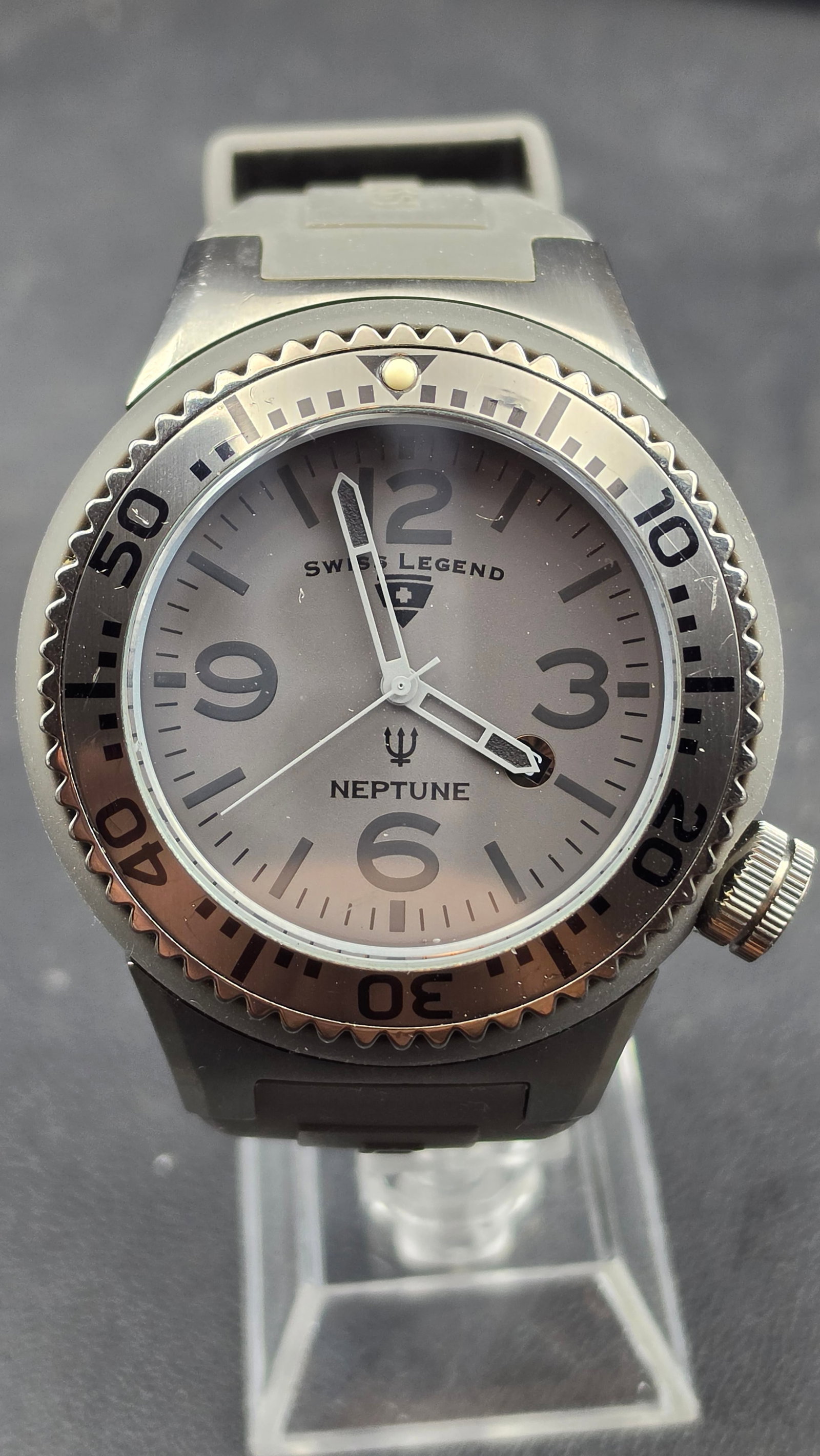 Swiss Legend Neptune Gray Gunmetal Dial Gray Silicone Strap Swiss Quartz No Date 52mm 2012: This is a Swiss Legend Neptune diver, powered by a Swiss quartz movement. The 52.18mm gunmetal ion-plated stainless steel case is fitted with gray silicone rubber lug protectors and presents a gray su