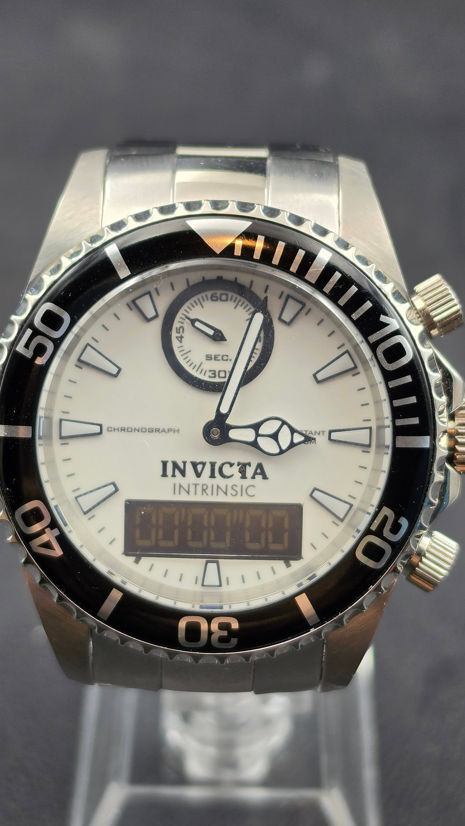 Invicta Intrinsic Model 12470 NOS 45mm Ana-Digi Chronograph White Dial Men's Watch: Invicta Intrinsic reference 12470, NOS example in excellent unissued condition. The 45.5mm stainless steel case features a bold black unidirectional dive bezel with white minute markers and white pip 