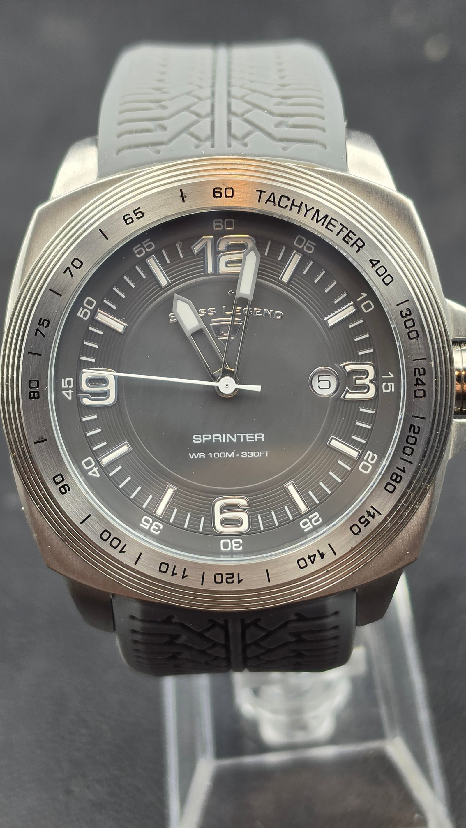 Swiss Legend Sprinter NOS Sapphitek Tachymeter Sport Watch Gray Tire-Tread Strap Ref 213006497: Swiss Legend Sprinter reference 213006497, NOS example in excellent unissued condition. The brushed 316L stainless steel cushion-form case features a motorsport-themed fixed tachymeter bezel with a mu