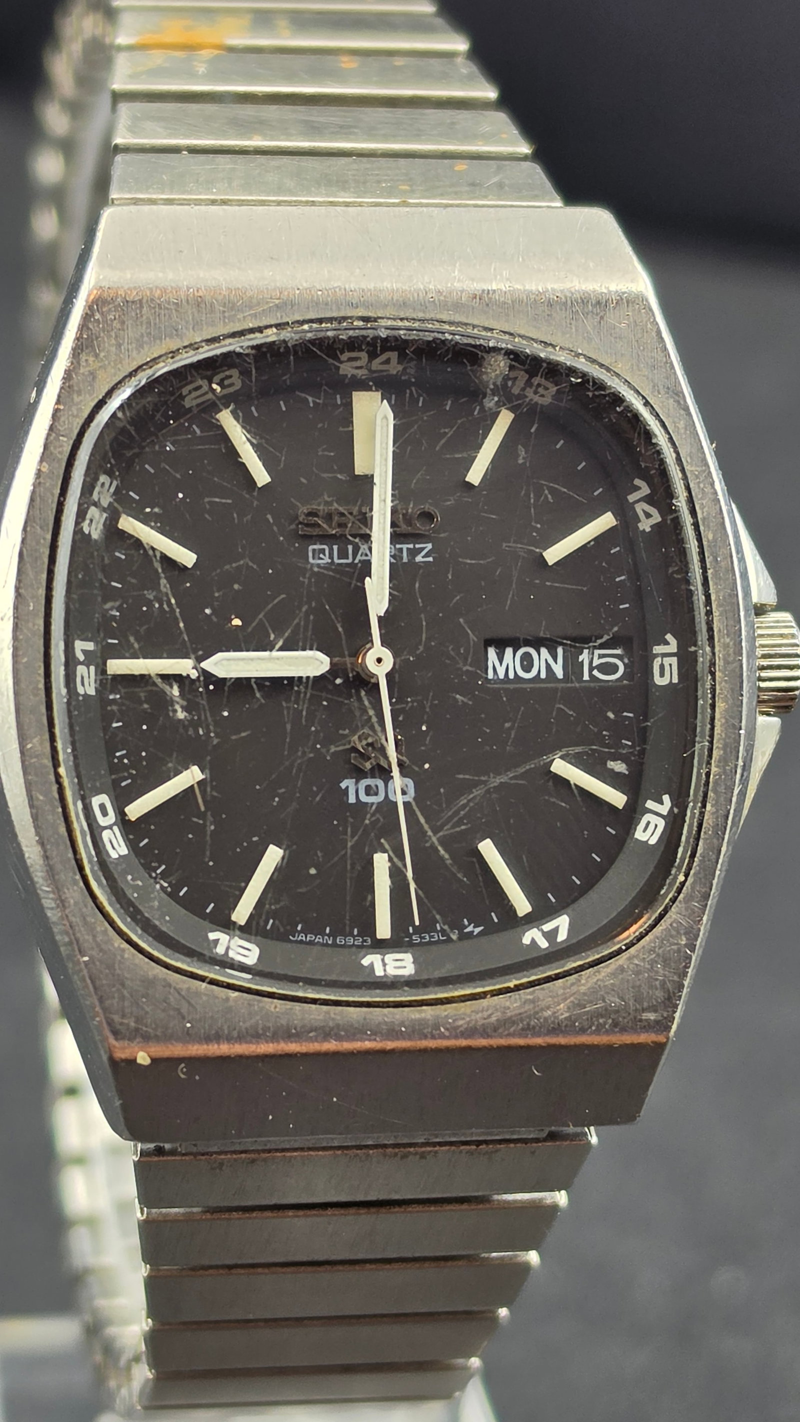 Seiko SQ 100 6923-5270 Black Dial 24-Hour Quartz Day-Date Stainless Steel 35mm Watch 1980s: This is a vintage Seiko SQ 100 reference 6923-5270, a classic early quartz era dress watch featuring a black dial with applied lume bar indices, lume hands, a full 24-hour chapter ring printed around 