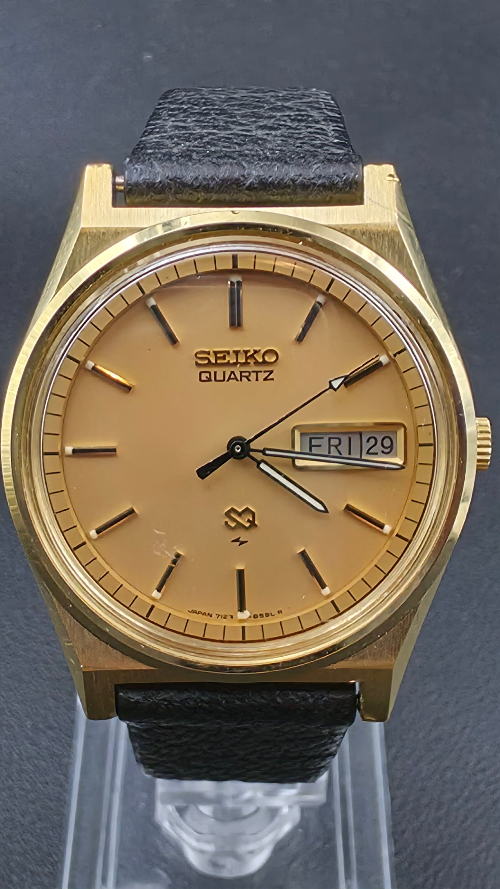 Seiko Quartz SQ 7123-8439 Gold-Tone Day-Date Champagne Dial Black Leather 1970s: This is a Seiko quartz day-date watch from the late 1970s, ref. 7123-8439-P, running Japan caliber 7123. The watch features a champagne gold-tone dial with applied black-tipped baton hour markers with