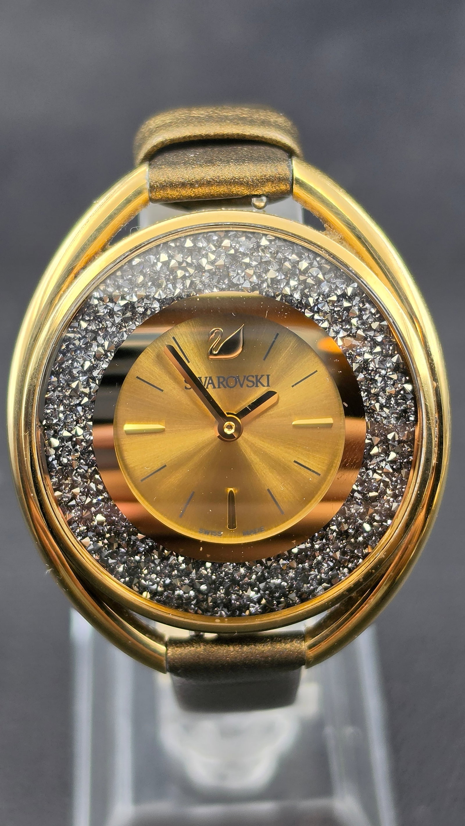 Swarovski Crystalline Oval Gold-Tone Crystal Rock Swiss Made Ladies Watch 5296314: This is a striking Swarovski Crystalline Oval ladies watch, reference 5296314, measuring approximately 37.28mm across the gold-tone oval case with its signature floating orbital ring frame. The gold s