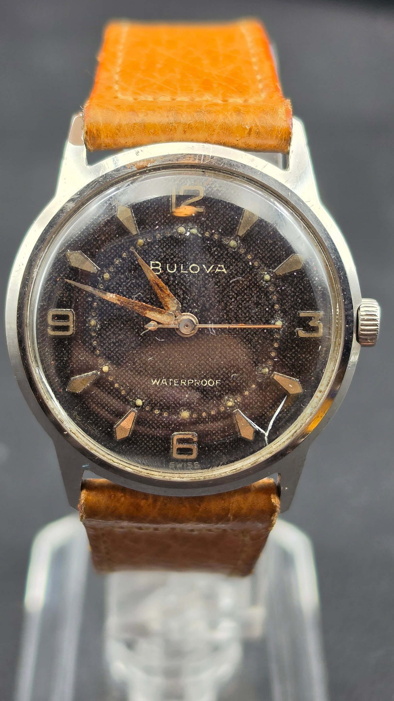Bulova Swiss 11AFC 17 Jewel Stainless Steel Black Textured Dial Men's Watch 31mm, 1960, Running: This is a Bulova Swiss dress watch, case serial 162013, date code M0 confirming 1960 production. The black textured linen-pattern dial carries Arabic numerals at 12, 9, 3, and 6, applied gold-tone arr