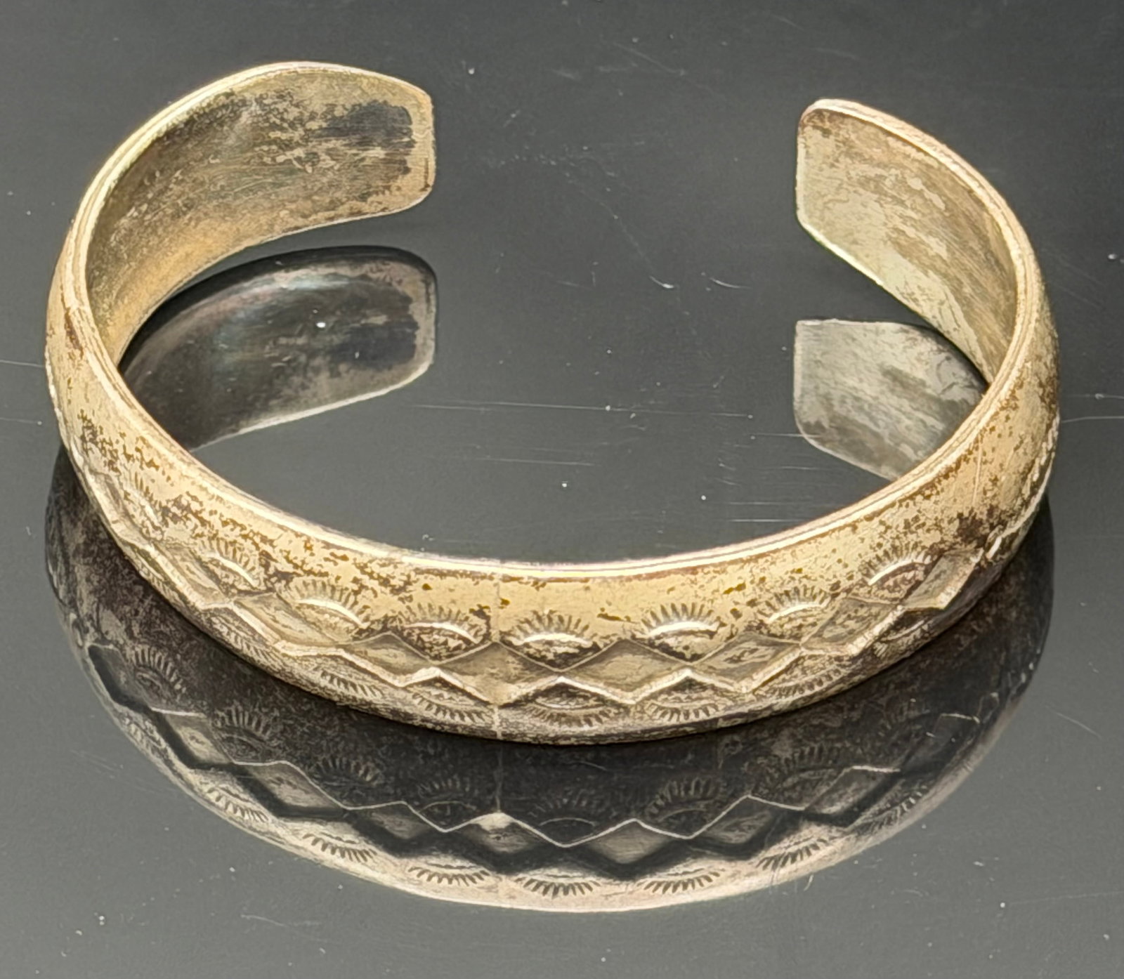 26g-Vintage Sterling Silver Stamped Southwestern Cuff Bracelet: Vintage sterling silver cuff bracelet featuring traditional Southwestern hand-stamped geometric designs. The wide band displays repeating diamond and sunburst motifs across the front, creating a timel