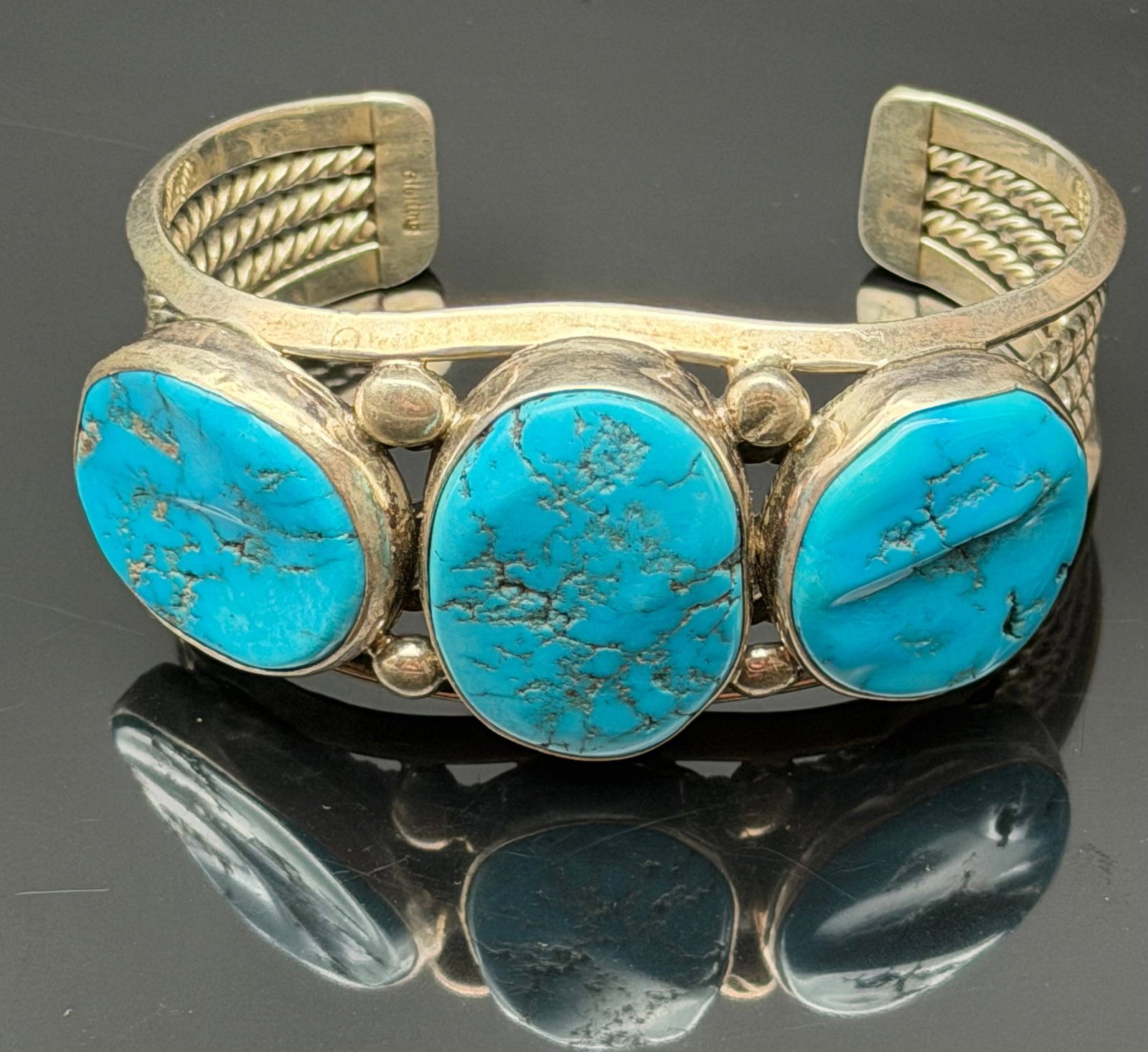 66g-Vintage Sterling Silver Three Stone Turquoise Cuff Bracelet: Beautiful vintage sterling silver cuff bracelet featuring three vibrant blue turquoise cabochons set across the front. The bracelet is accented with heavy twisted silver wire and traditional Southwest