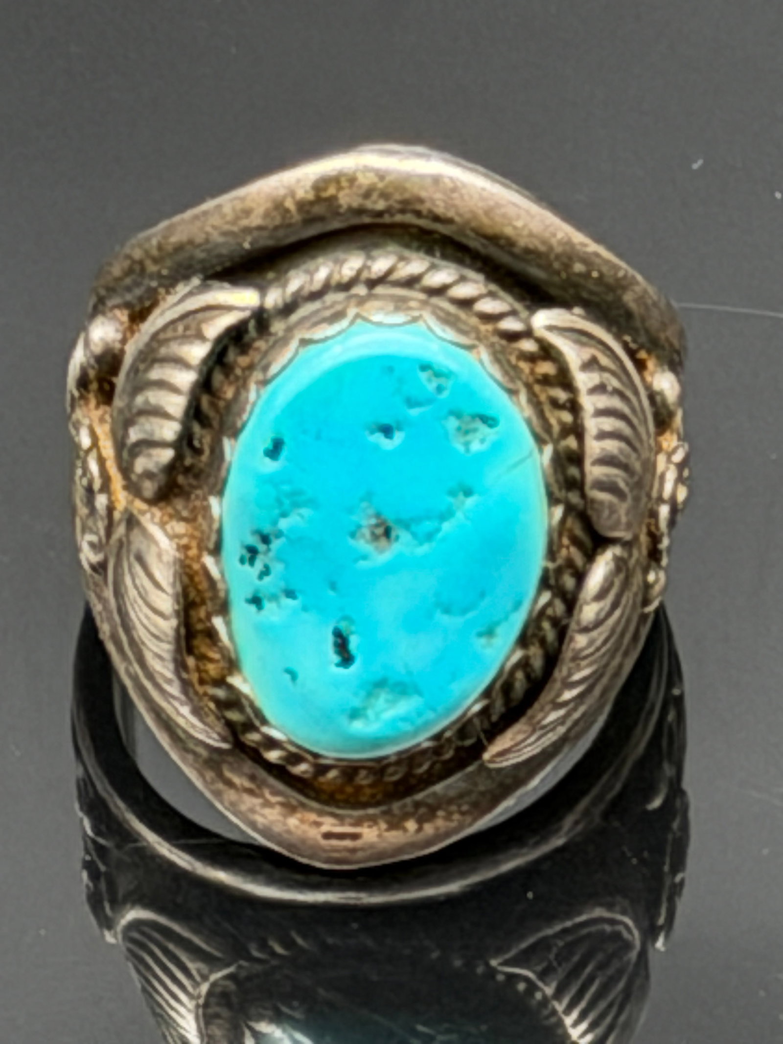 13g-Vintage RB Sterling Silver Turquoise Ring: Beautiful vintage sterling silver ring featuring a natural turquoise cabochon accented by rope and feather-style detailing. Marked RB STERLING inside the band. The vibrant blue turquoise stone contras