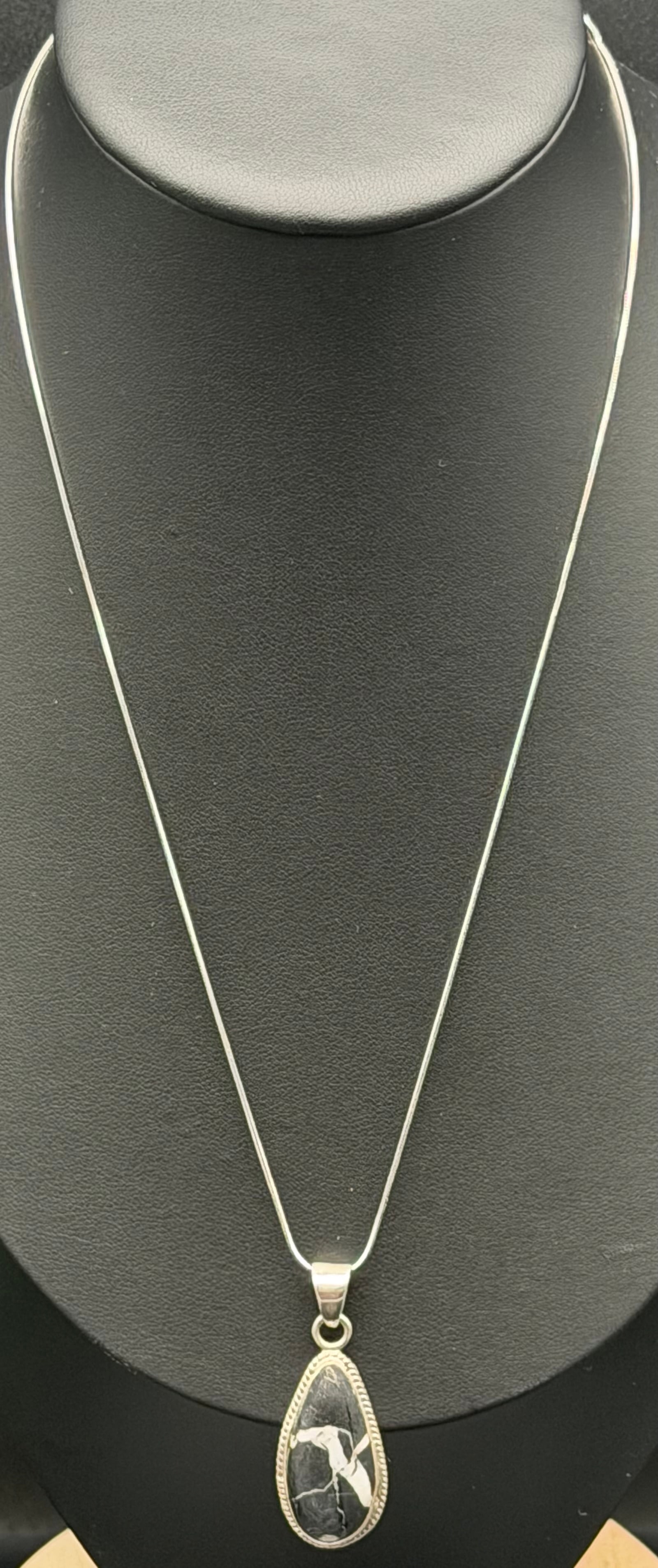 7g-Vintage OP Sterling Silver Black Onyx Inlay Southwest Pendant Necklace: Vintage sterling silver pendant necklace by OP (Oscar Pardiñas). Features a teardrop-shaped black stone inlay with an etched Southwest-inspired figure motif. Set in a sterling silver frame with rope 