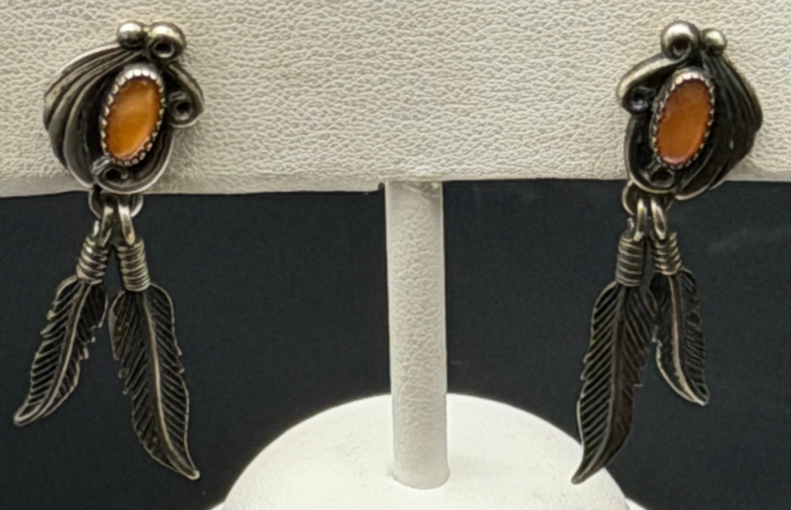 5g-Vintage Native American Sterling Silver Feather Dangle Earrings: Vintage sterling silver Southwestern dangle earrings featuring detailed feather drops and oval orange cabochon stones. Marked “STER” on the reverse with a maker’s mark. Classic Native Americ